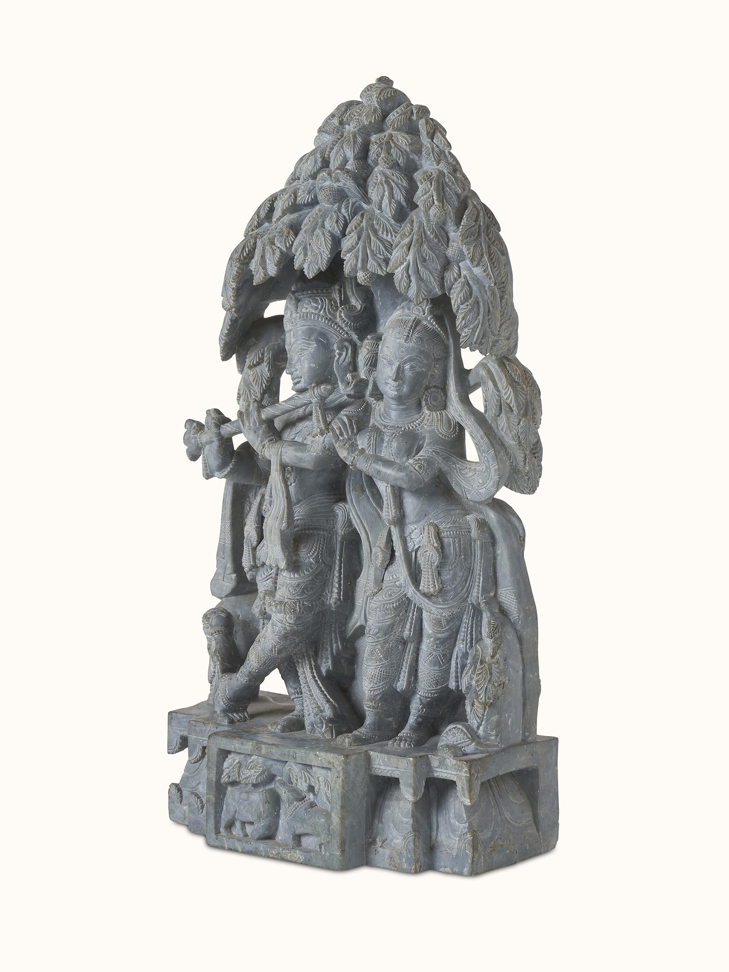 Close-up of carved stone Radha & Krishna in love idol highlighting detailed carving and graceful depiction.