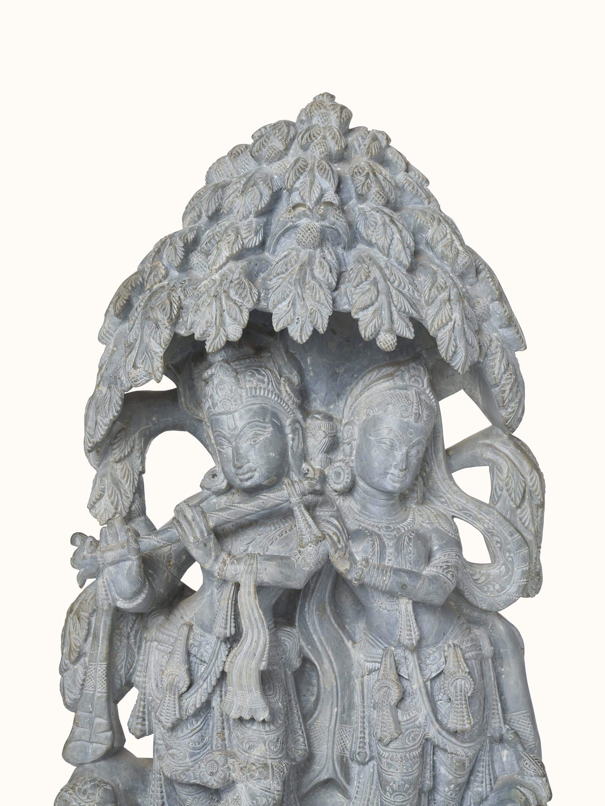 Detailed view of carved stone Radha & Krishna in love idol displaying exquisite craftsmanship and emotional expression.
