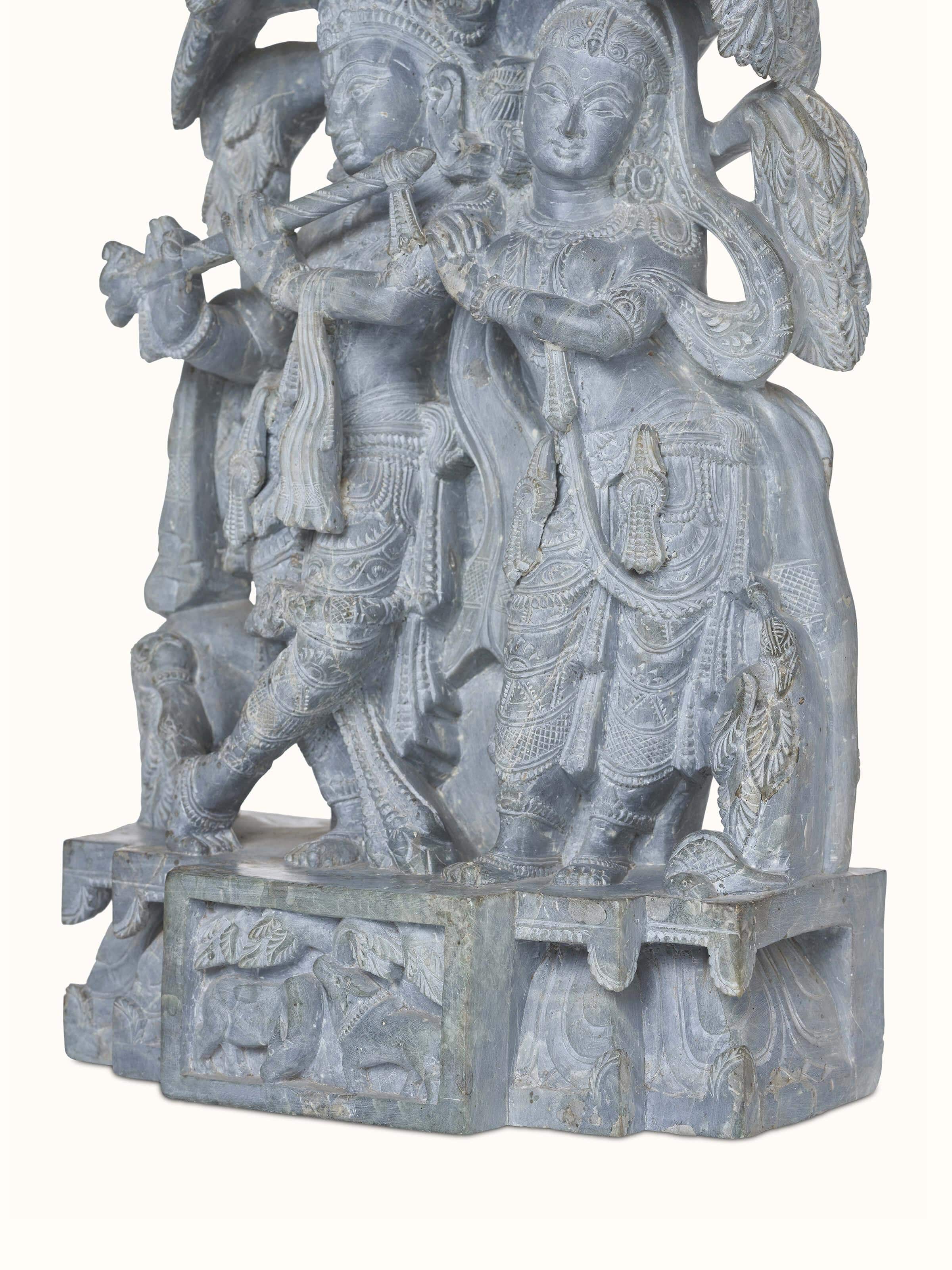 Back view of carved stone Radha & Krishna in love idol emphasizing the fluidity of the pose and detailed design.
