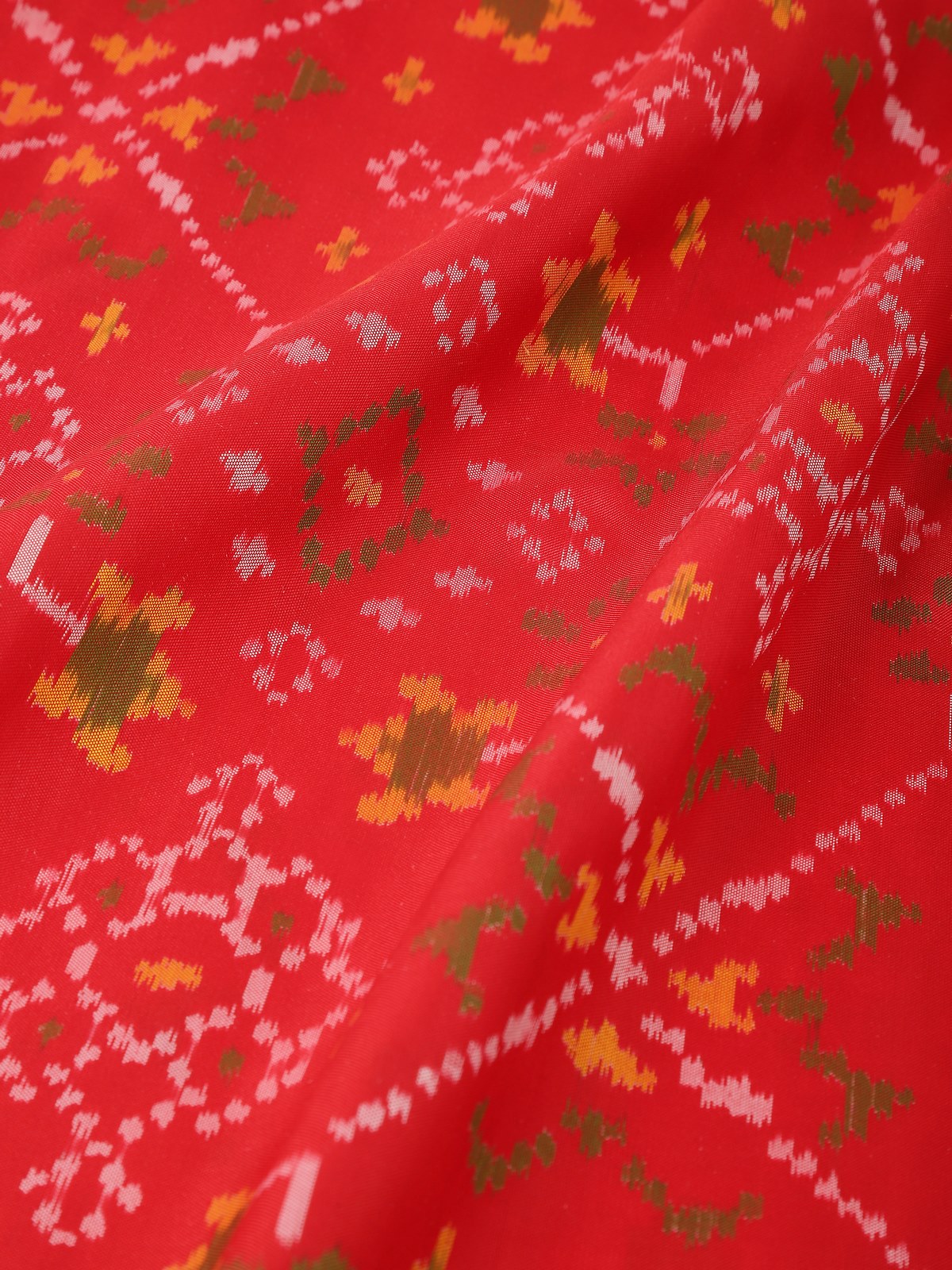 Detail view of red silk Ikat dupatta highlighting fine weave and vibrant color transitions