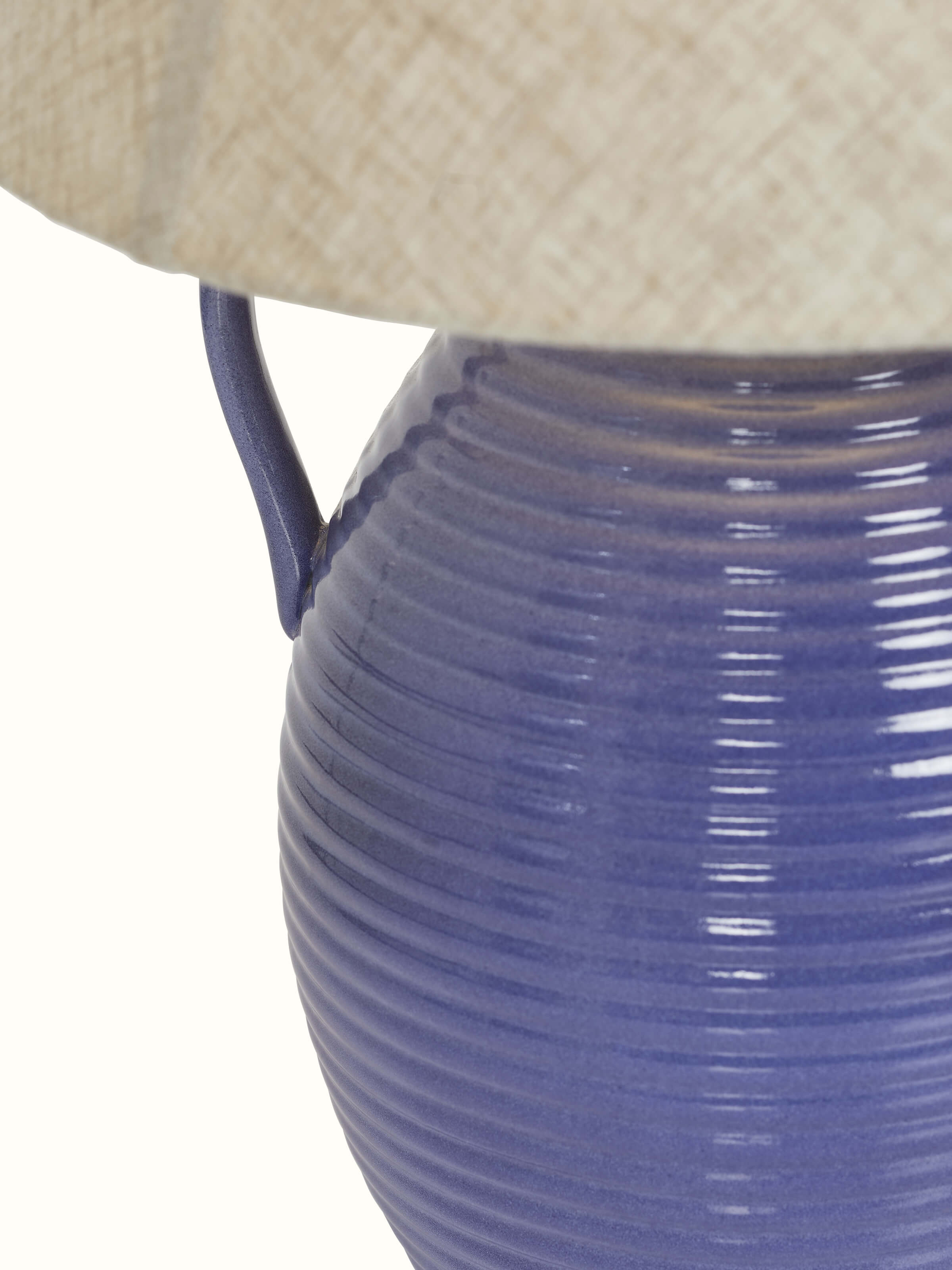 Angled view of the off-white studio pottery & cotton table lamp, displaying its stylish base and shade.