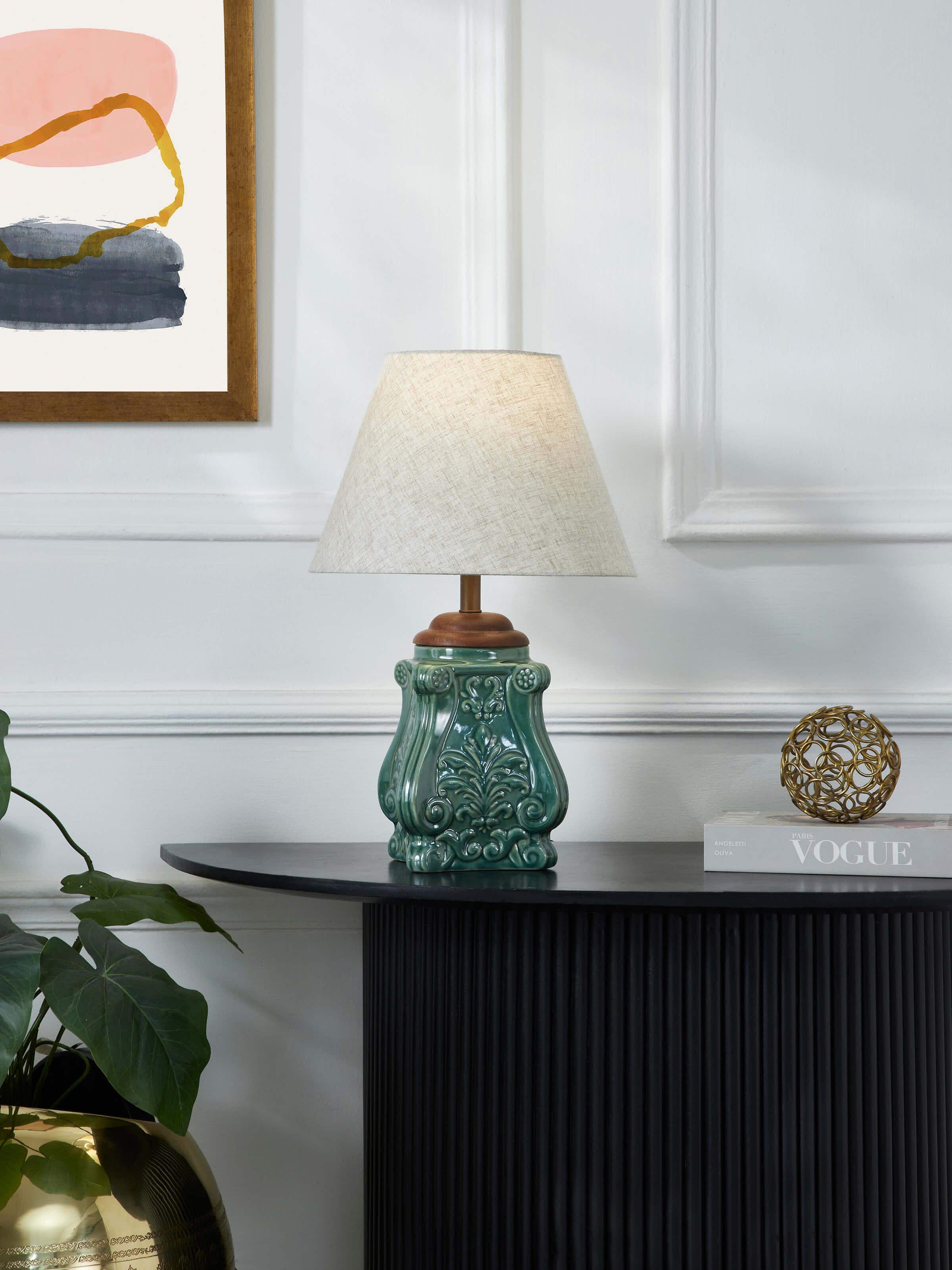 Close-up view of the studio pottery and cotton LED table lamp, highlighting the intricate details of the blue ceramic base and the cotton shade.