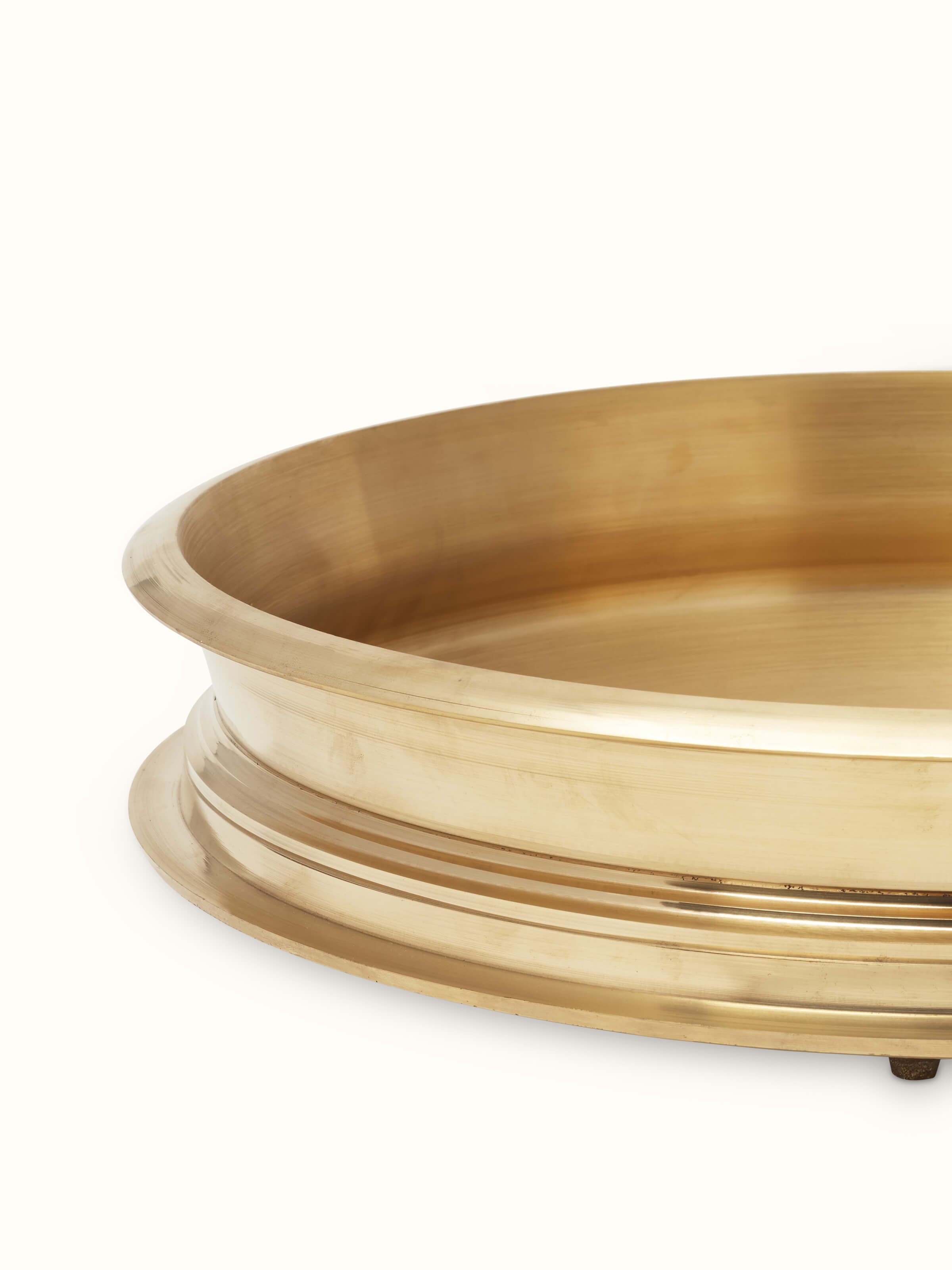 Angled view of Traditional brass urli emphasizing its decorative details and overall finish.