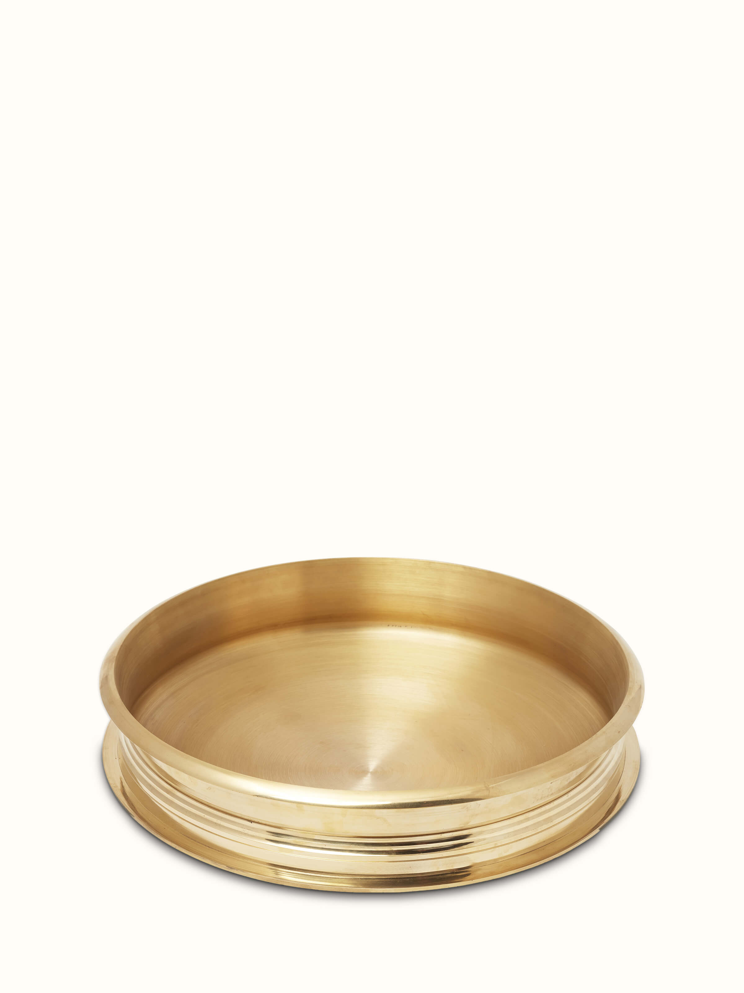 Side view of transitional brass urli showing its elegant shape