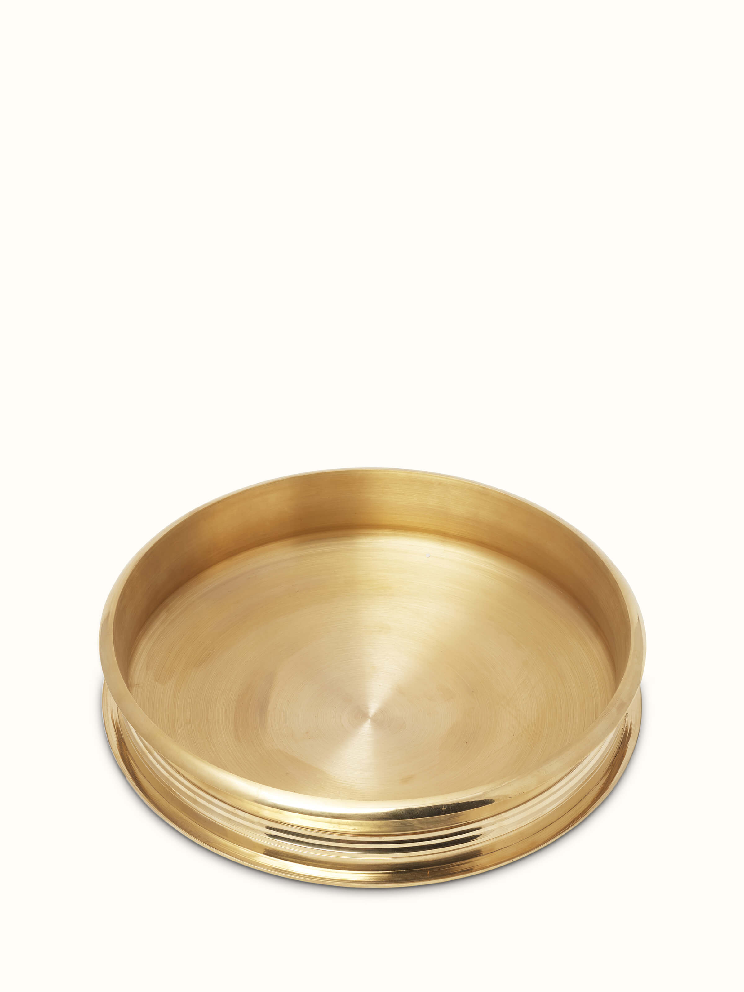 Close-up of transitional brass urli focusing on its smooth, polished surface