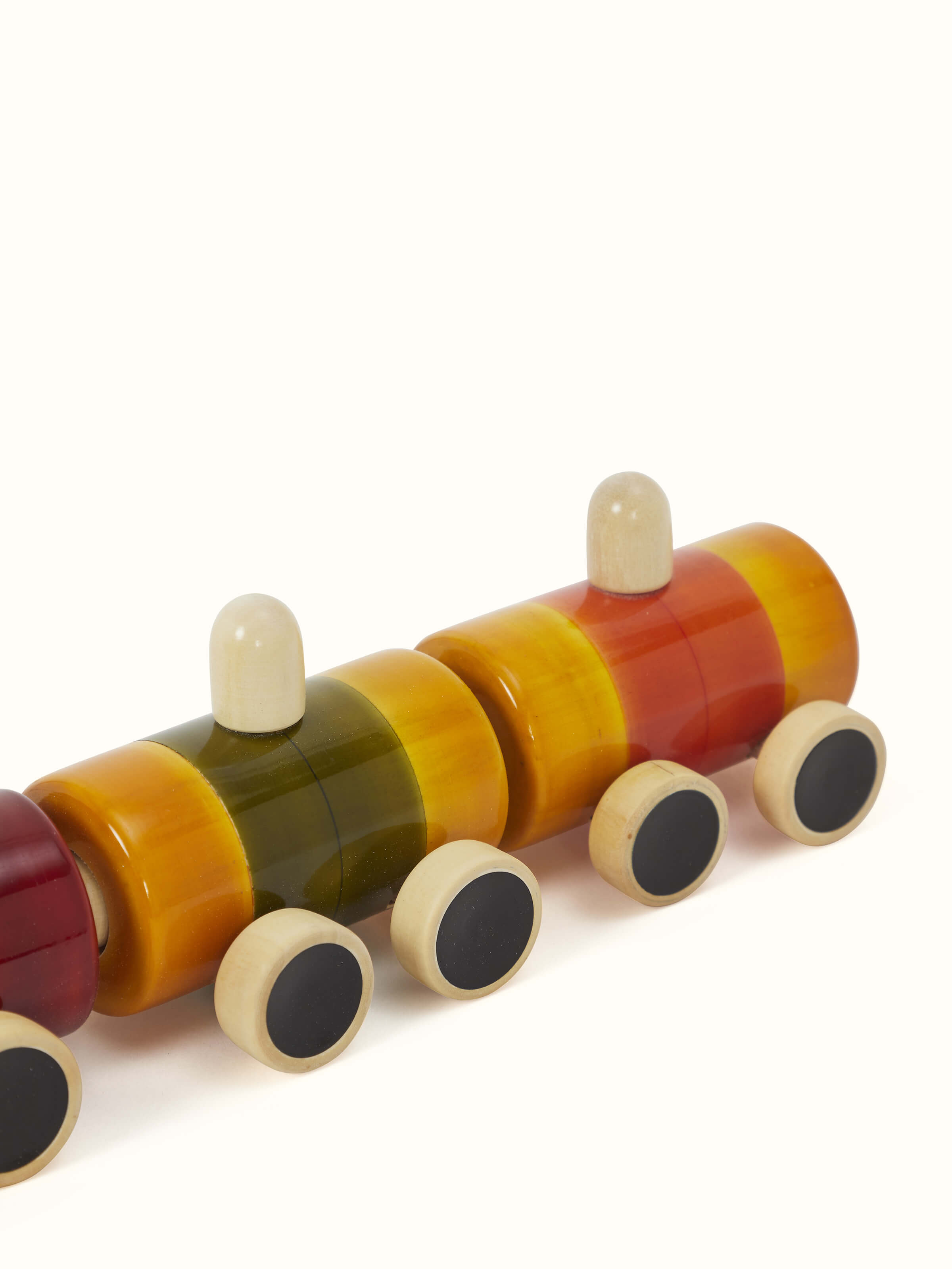 Detailed view of Channapatna White Wood Pom Pom Rail Toy focusing on its vibrant pom-poms and smooth wood texture