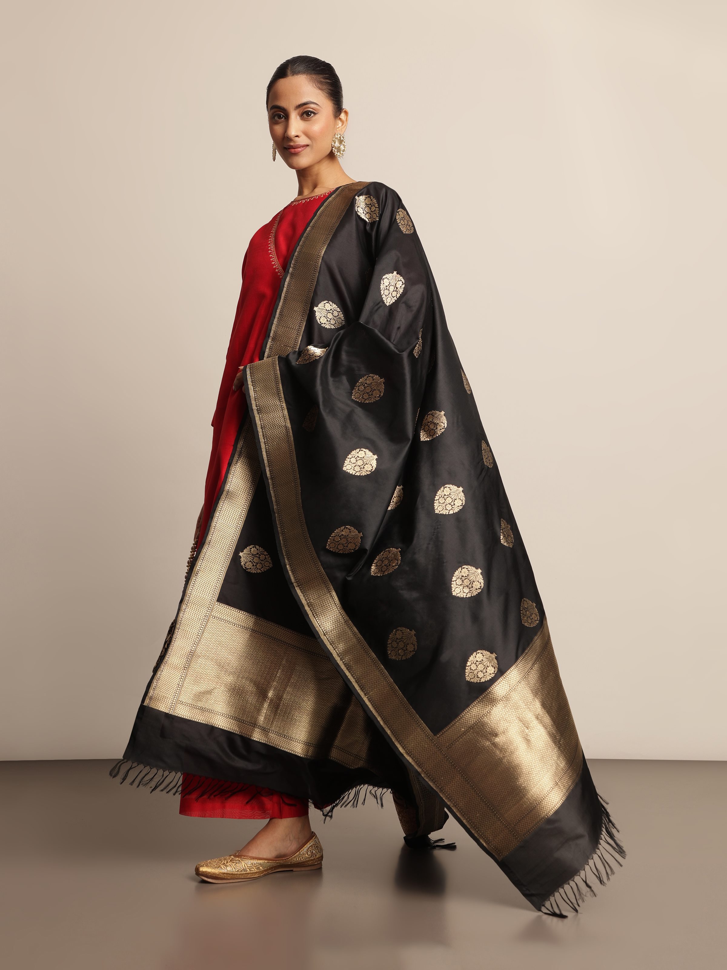 Model draped in black Banarasi silk dupatta showcasing luxurious gold woven patterns.