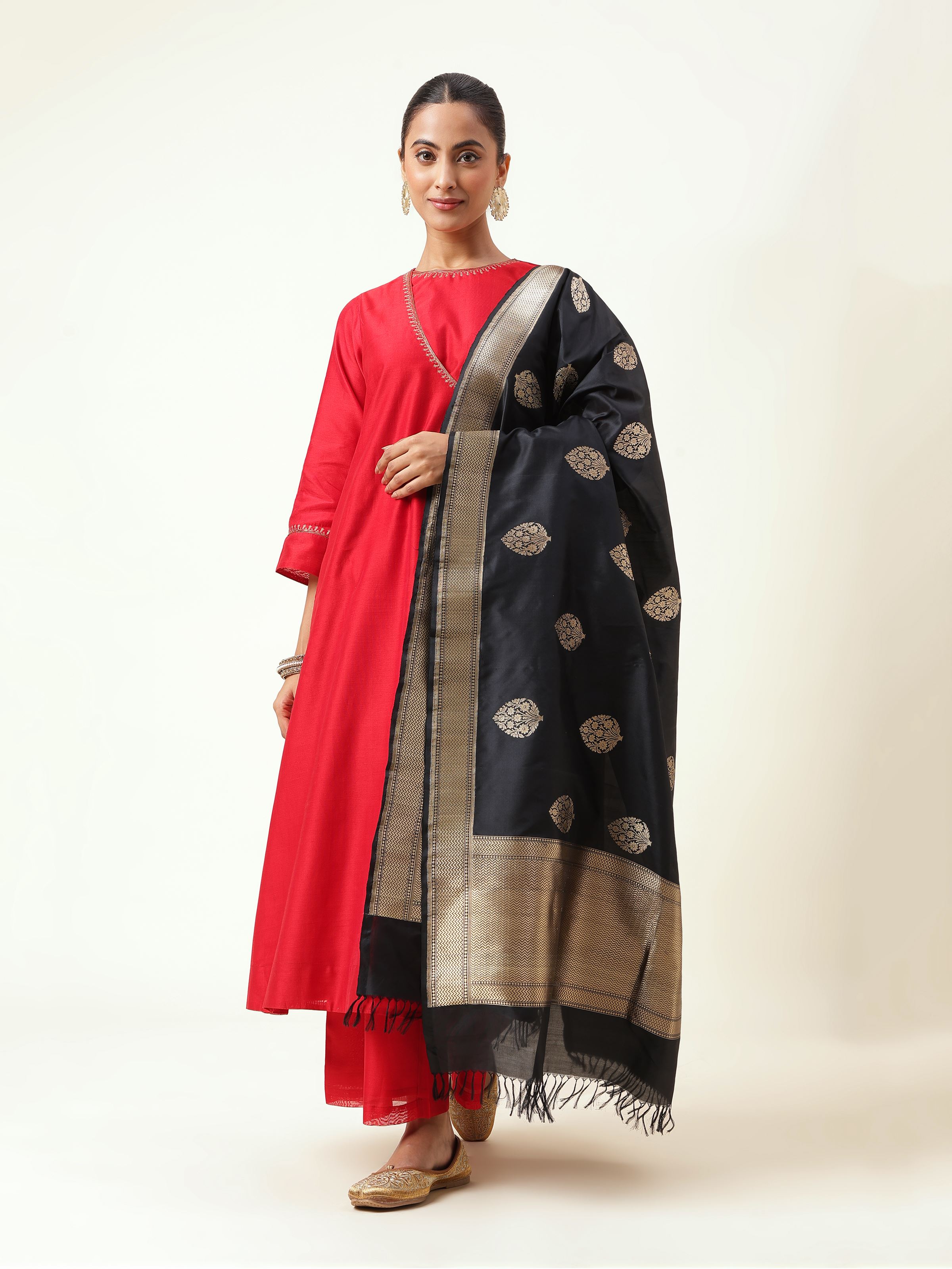 Folded black silk Banarasi dupatta laid flat, emphasizing fabric sheen and classic motif alignment.