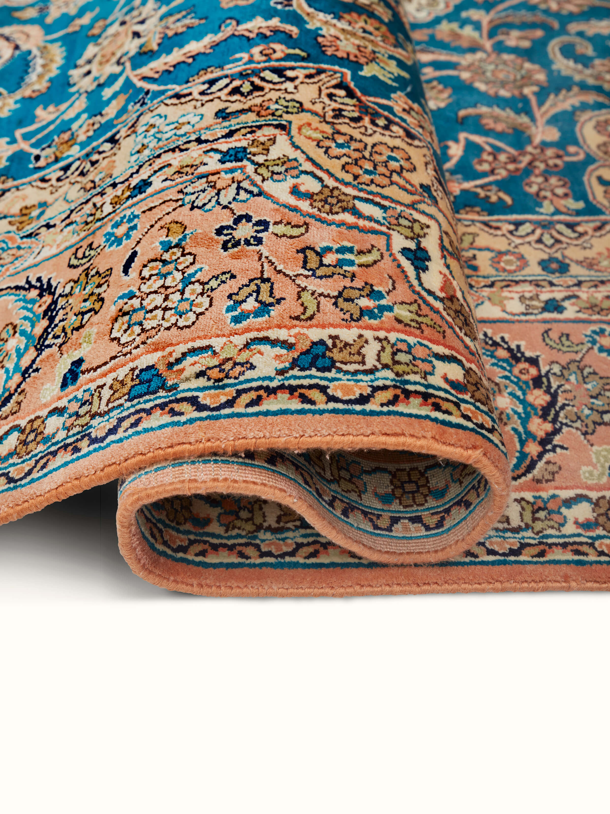 Traditional Persian teal rust Kashan Kashmir silk hand-knotted carpet in a room setting, emphasizing its elegance