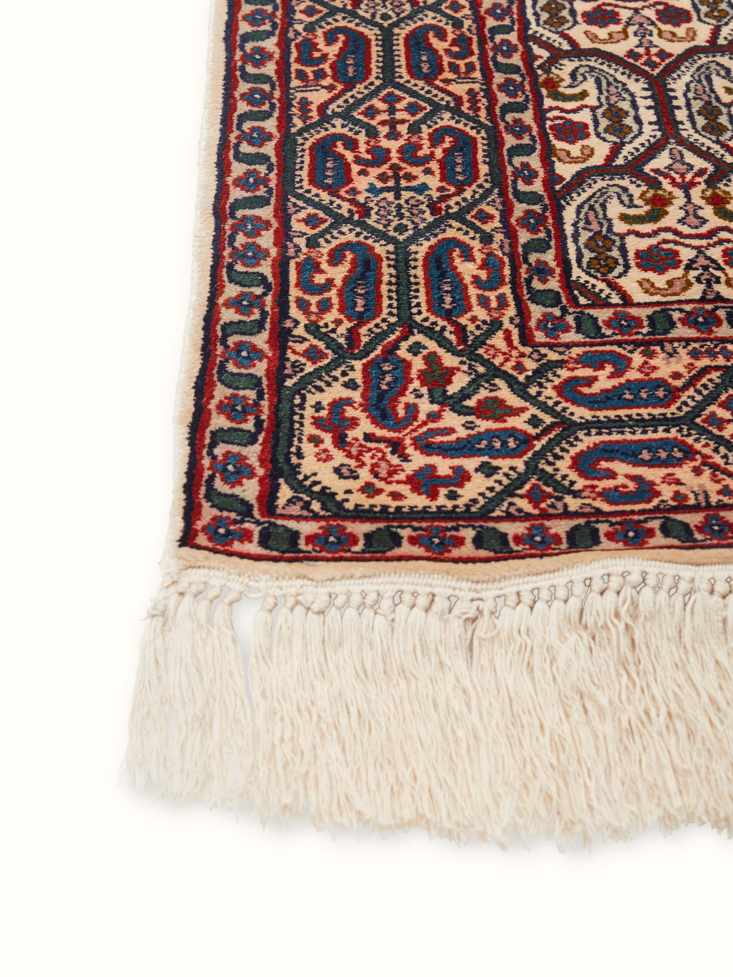 Angled view of a Persian hand-knotted silk carpet from Kashmir, showcasing the detailed craftsmanship and luxurious texture.