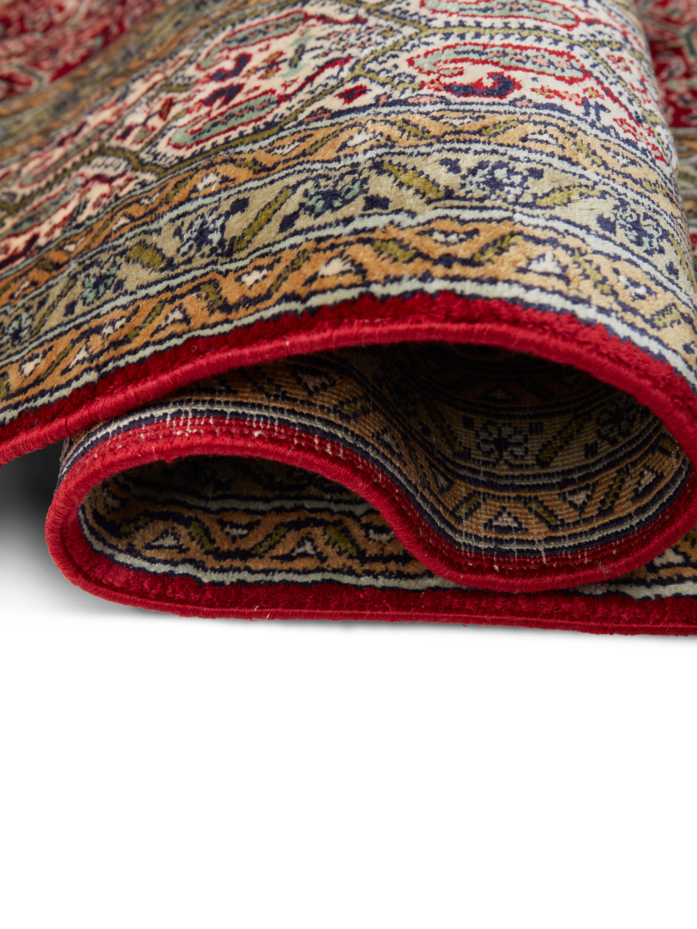 Side view of Traditional Persian Red Senna Kashmir Silk Hand-Knotted Carpet displaying the thickness and texture of the silk weave.