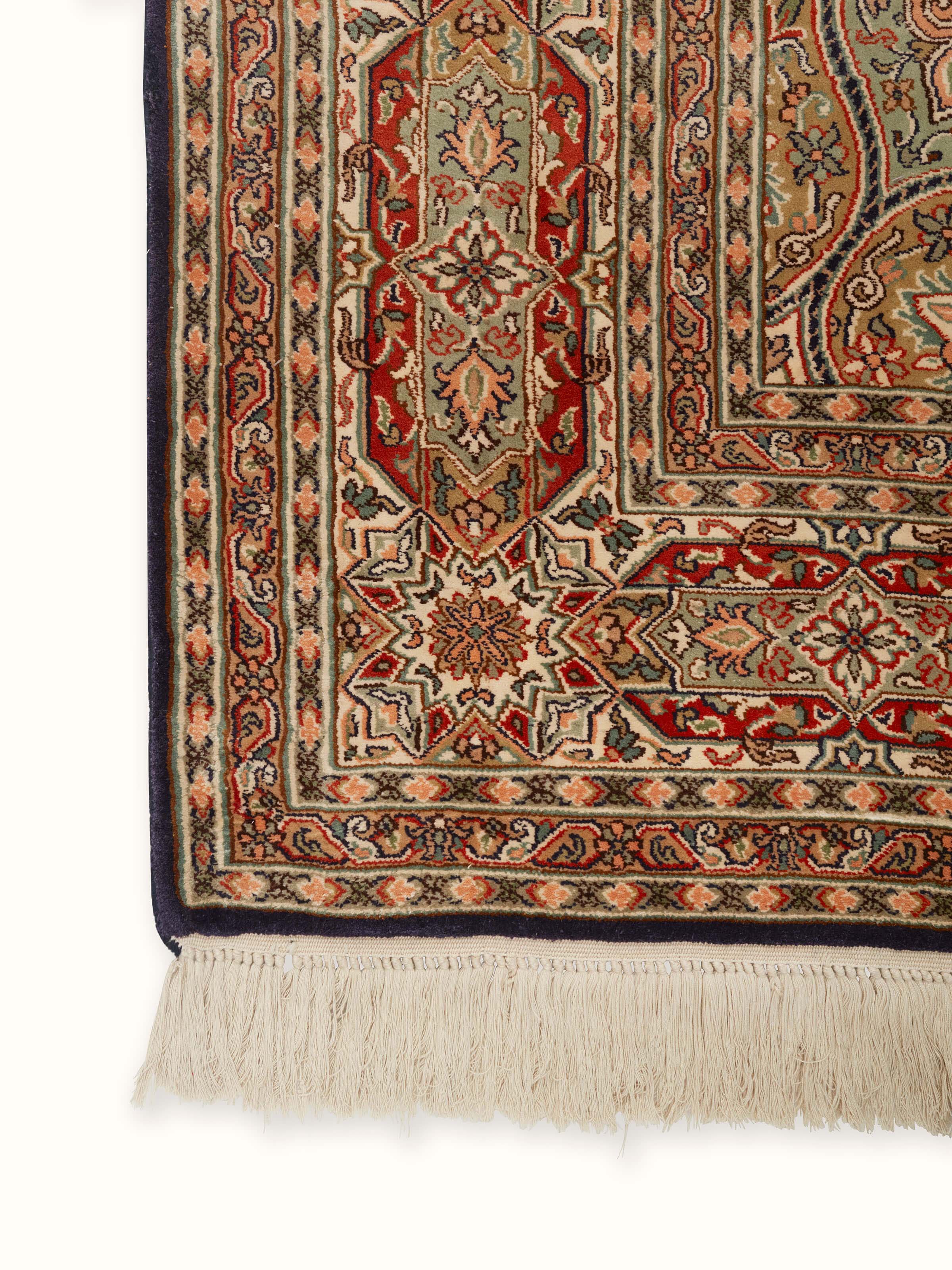 Close-up of Traditional Persian rust gumbad Kashmir silk hand-knotted carpet, highlighting the fine silk texture and detailed craftsmanship.