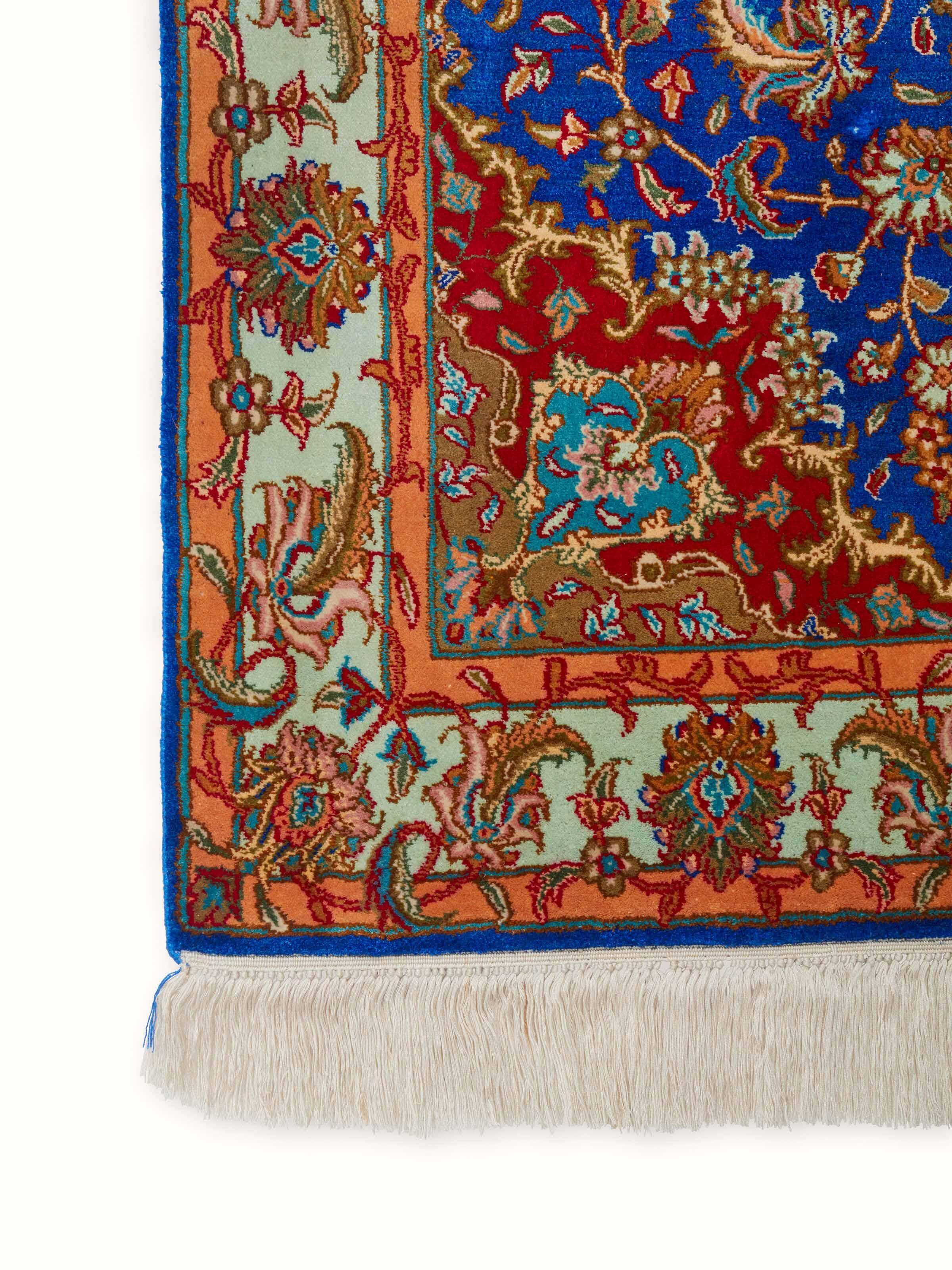 Traditional Persian Blue Red Kashan Kashmir silk hand-knotted carpet displayed on the floor, showcasing its design and size in a room setting.
