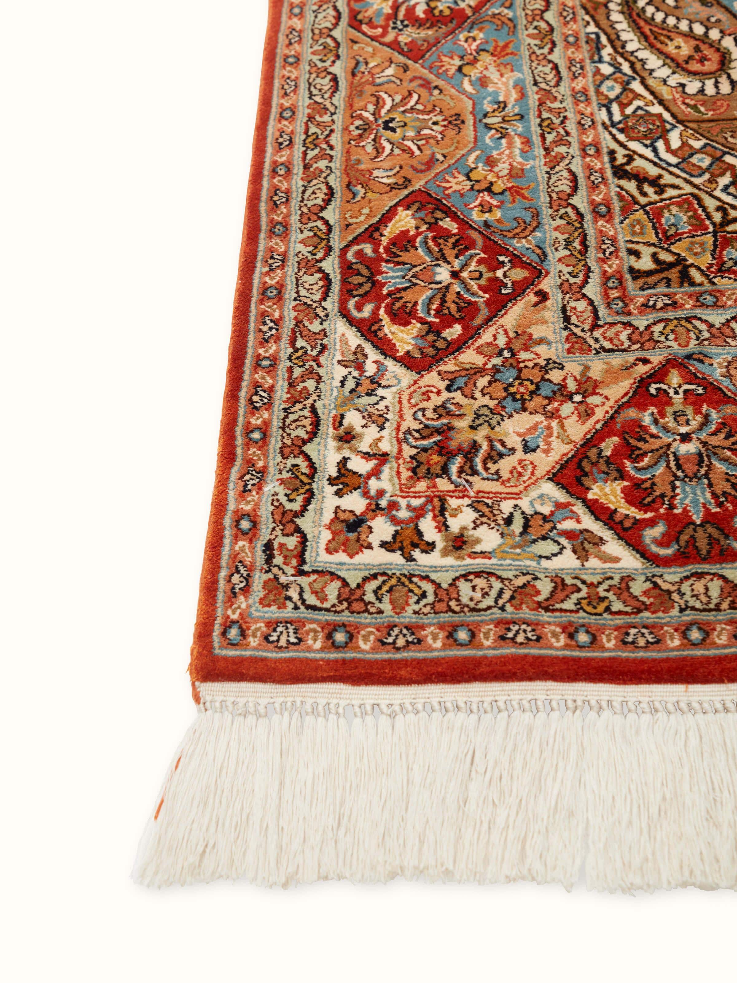 Angled view of Traditional Persian rust khatamband Kashmir silk hand-knotted carpet highlighting its detailed patterns