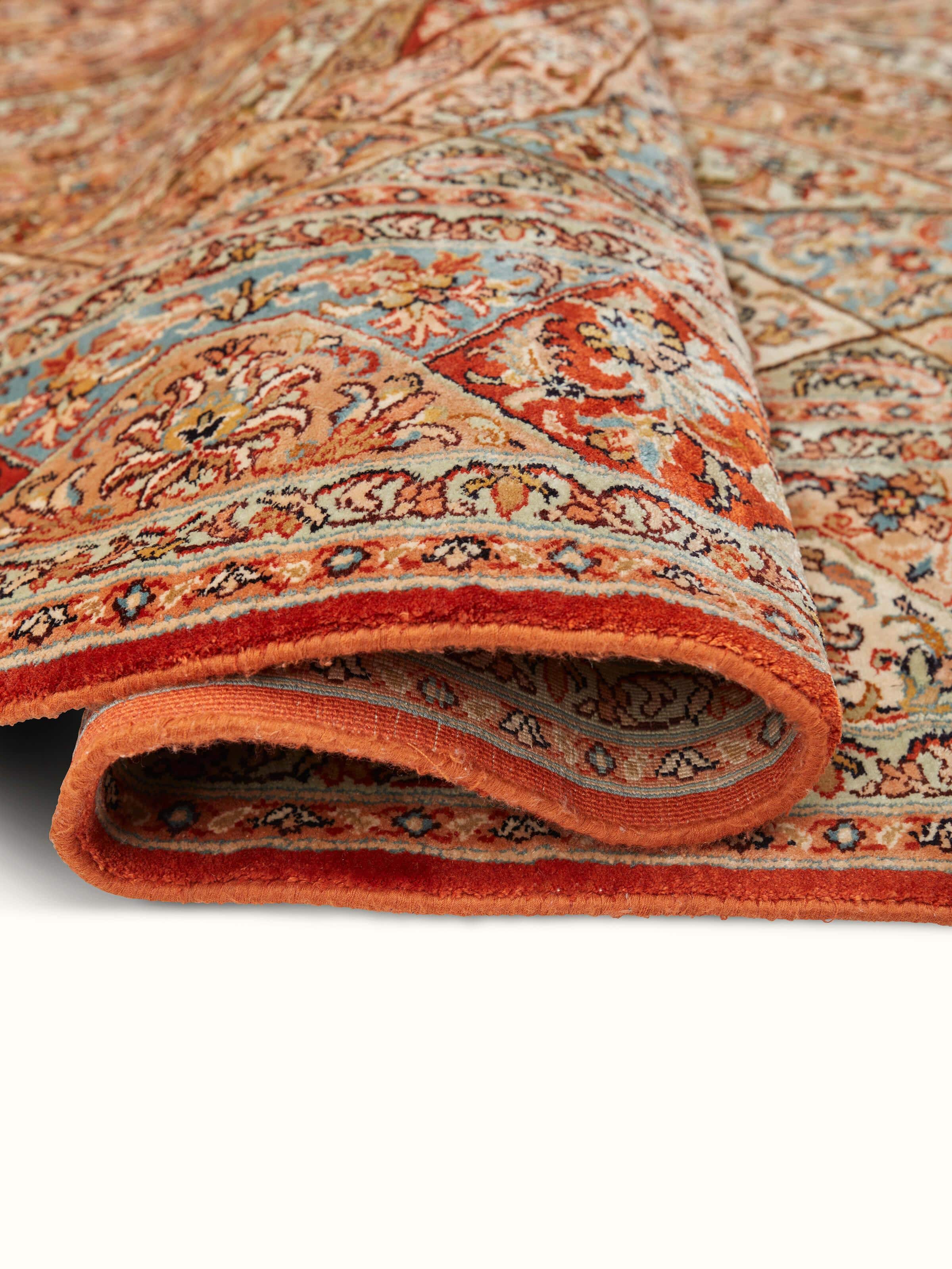 Close-up of Traditional Persian rust khatamband Kashmir silk hand-knotted carpet emphasizing its luxurious texture