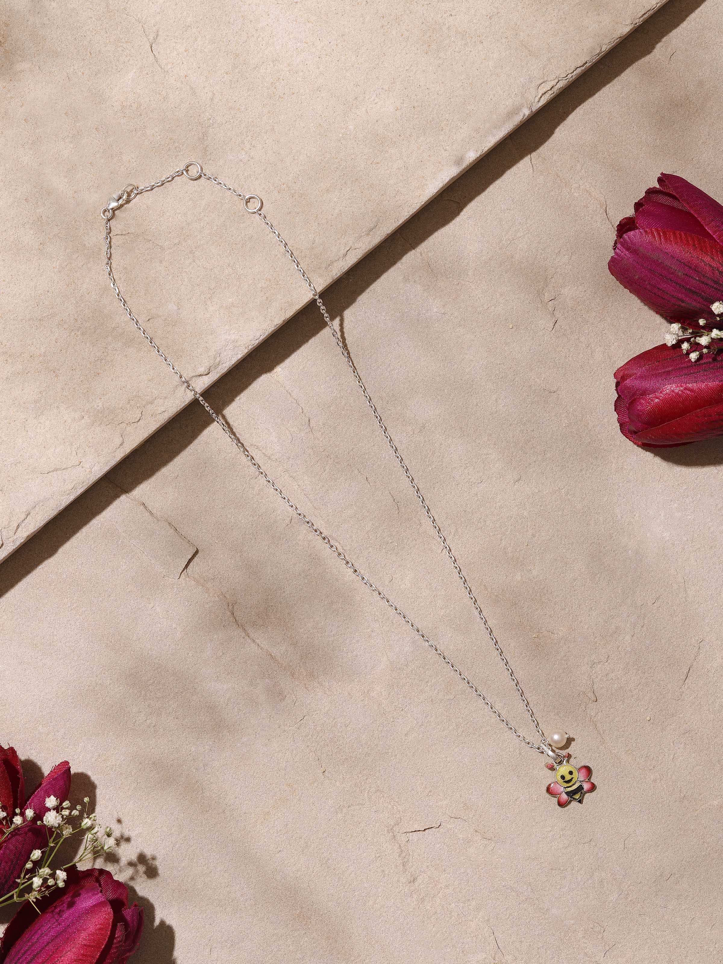 Angled side view highlighting the meenakari design and silver chain attached to the pendant