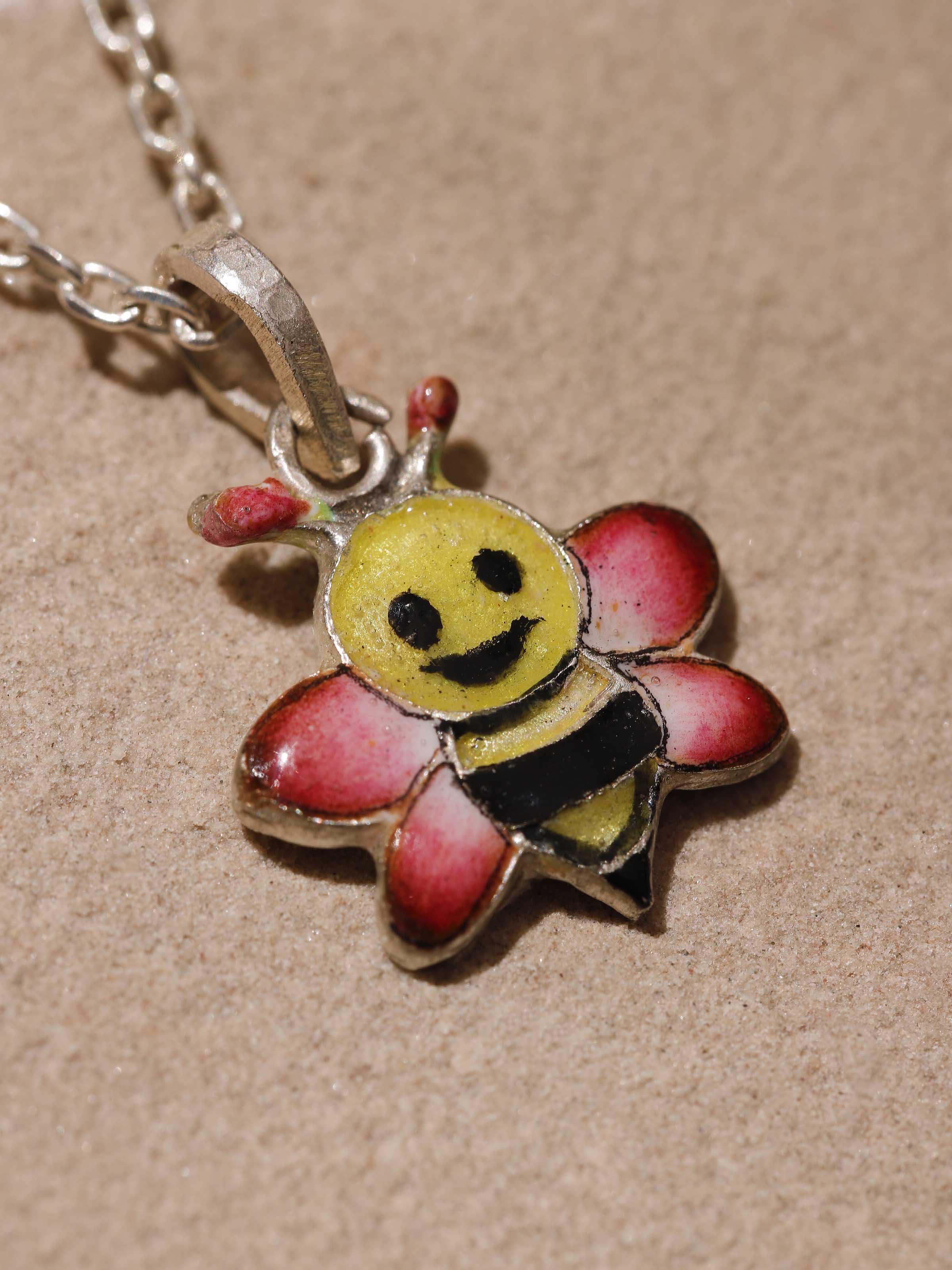 Side profile emphasizing the polished silver finish and vibrant pink enamel details