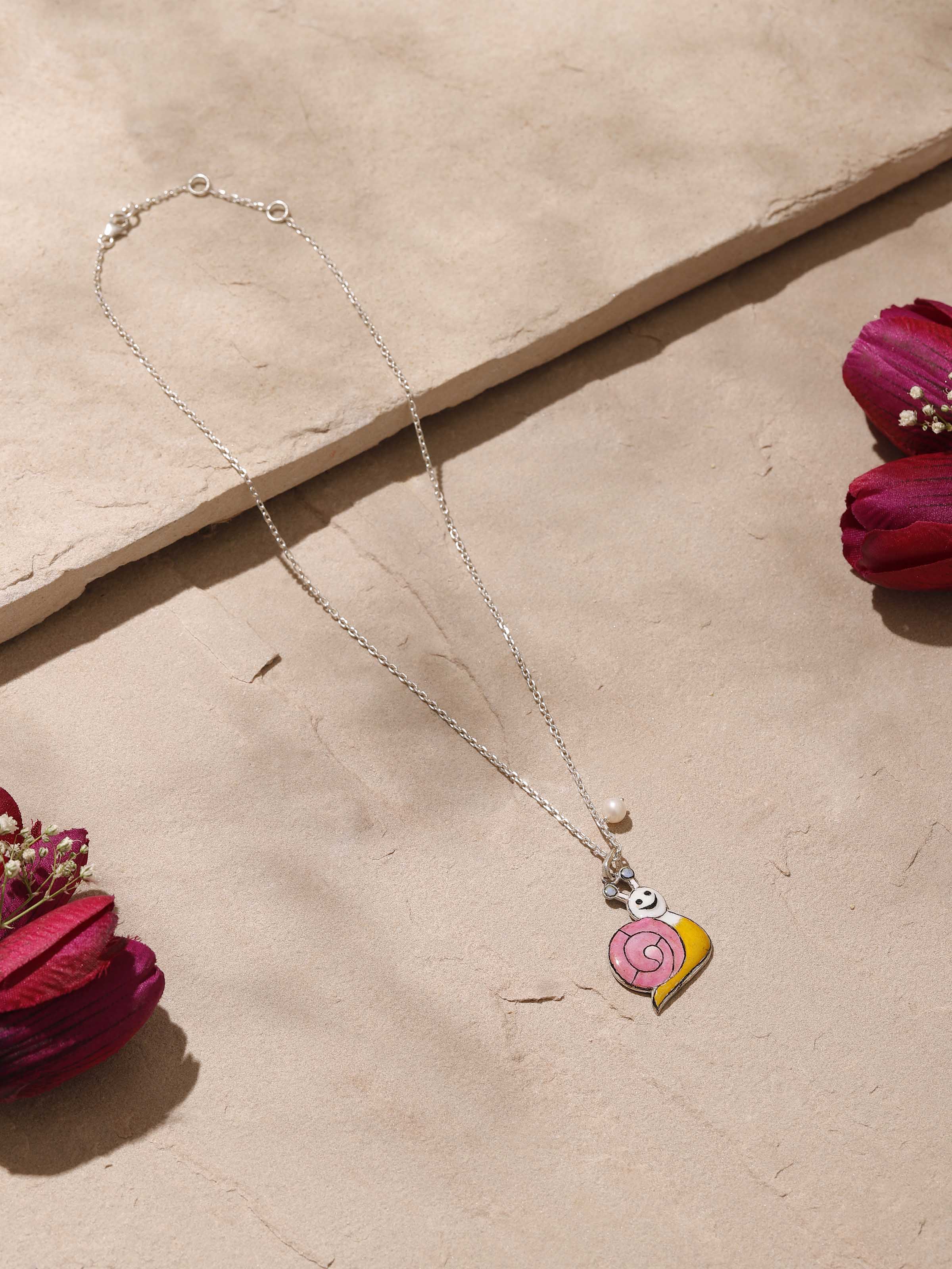 Close-up top view showcasing craftsmanship and pink meenakari work on silver pendant