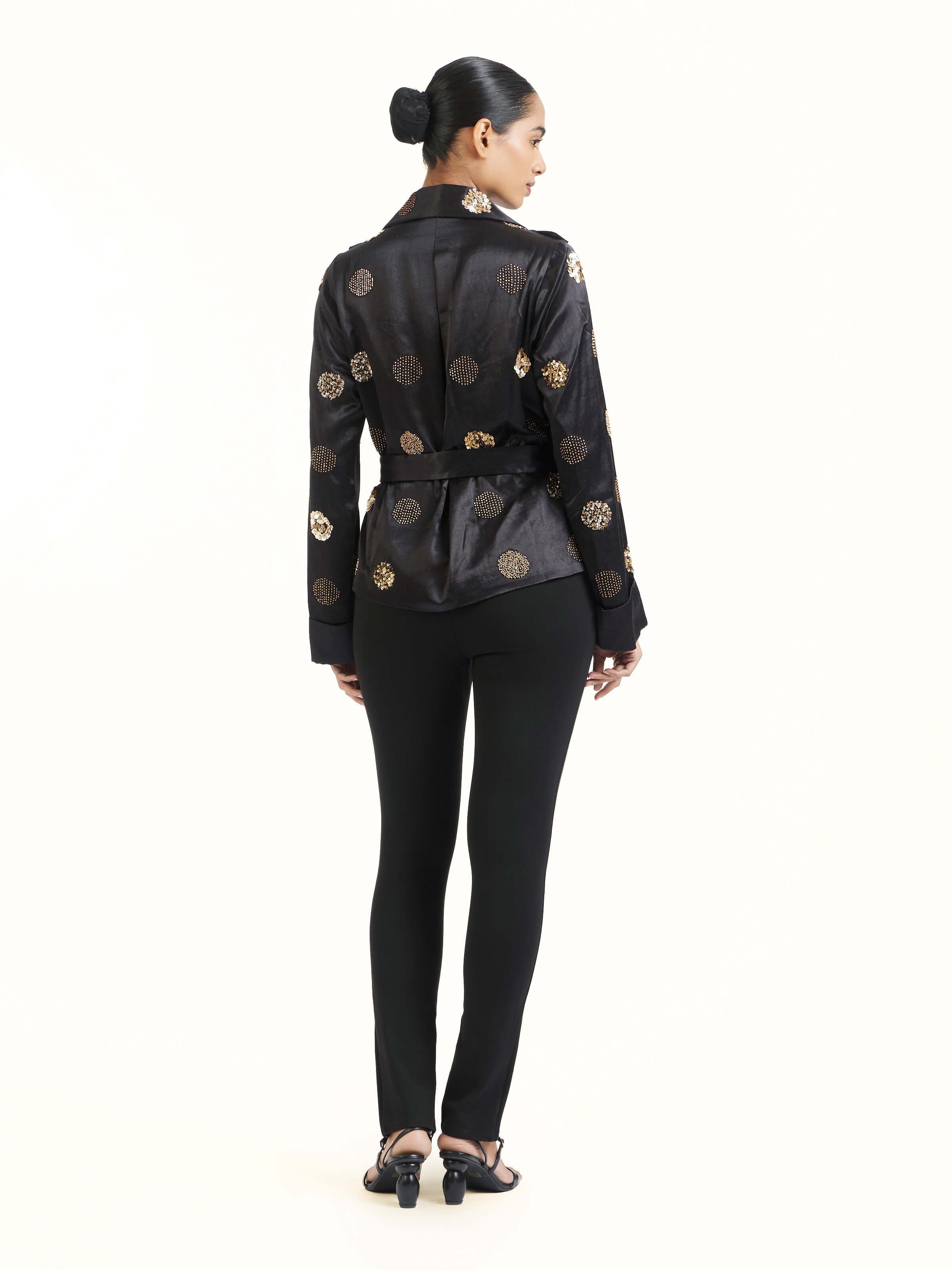 Back view of black hand embroidered dotted gold jacket displaying design elements