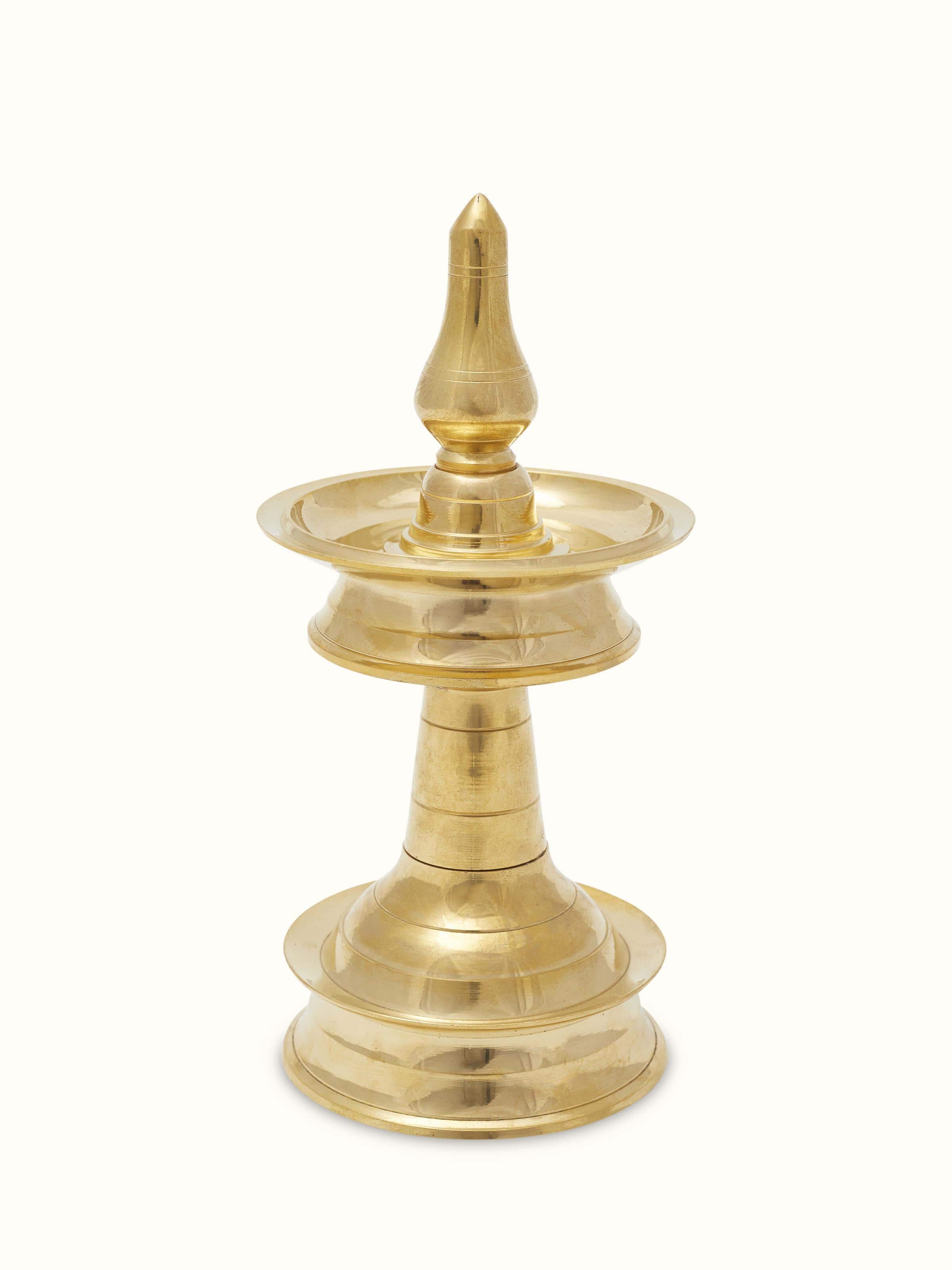Angled view of traditional brass samai vilakku stand diya highlighting intricate detailing and finish