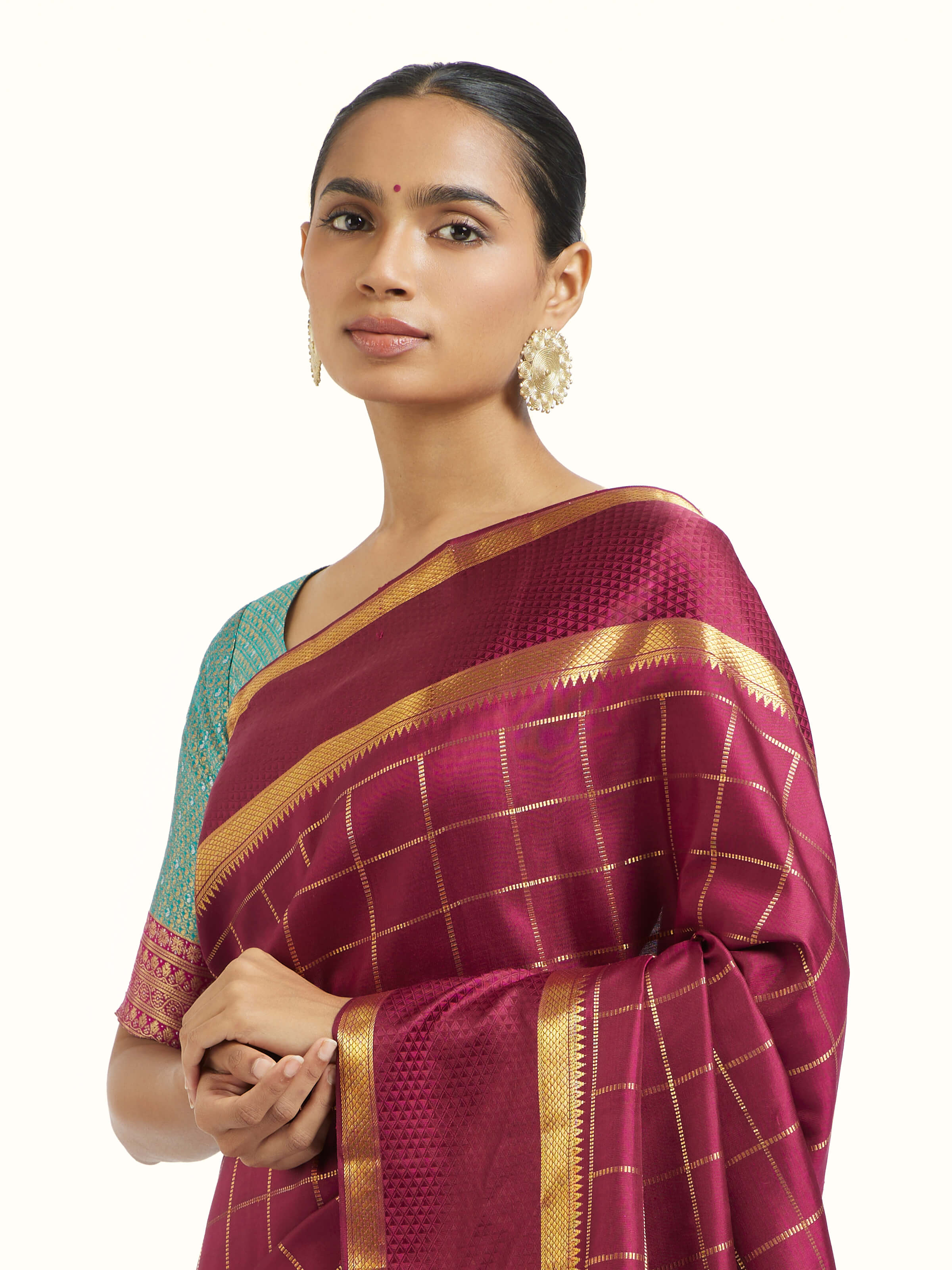 Angled view of burgundy silk Kancheepuram saree highlighting traditional silk weave