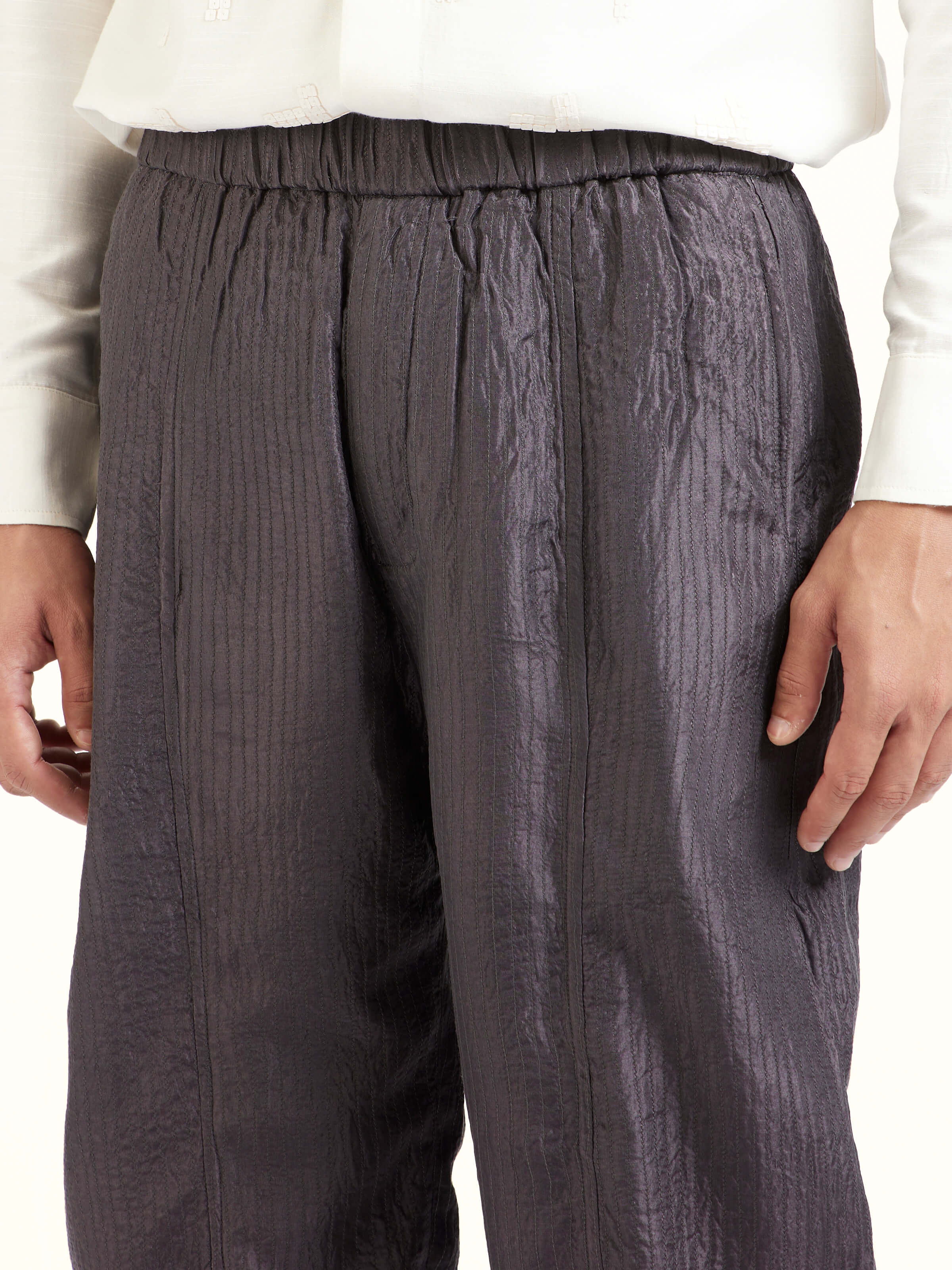 Detail view of grey straight quilted tulip pure silk pants showcasing fine stitching