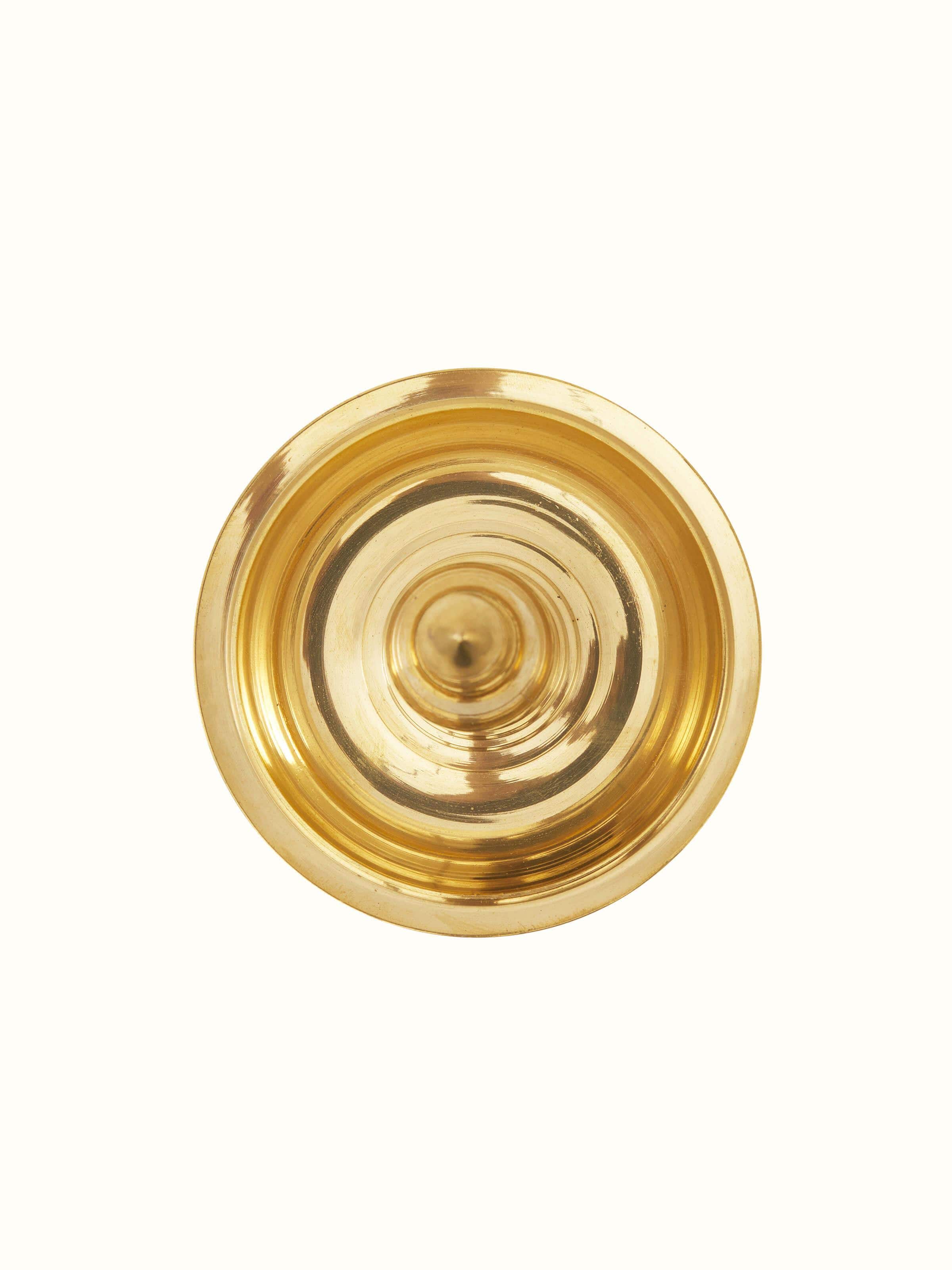 Angled close-up view of traditional brass samai vilakku stand diya emphasizing ornate patterns and classic craftsmanship