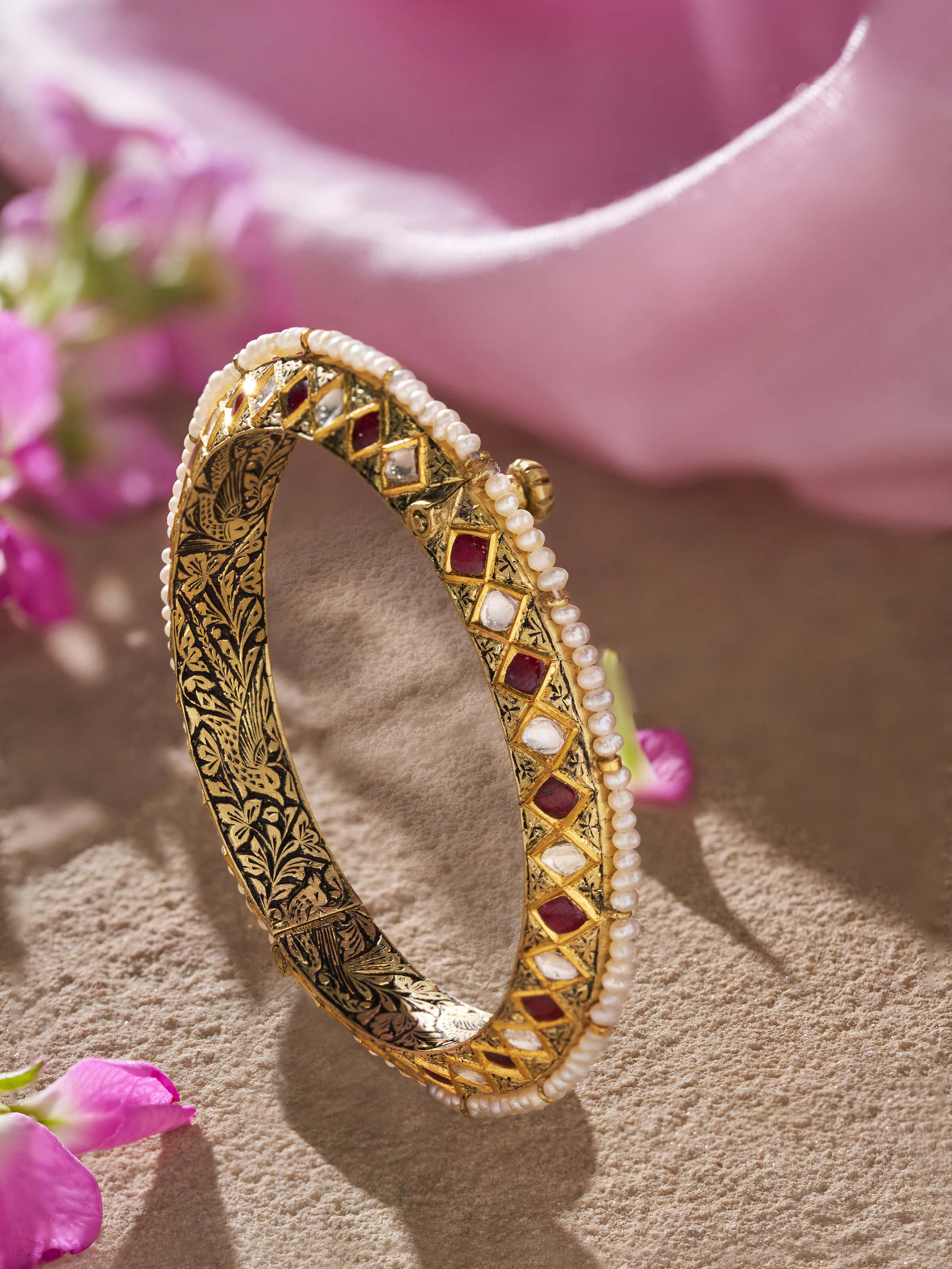 Angled view of 18 karat gold bangle showing elegant curves and shine