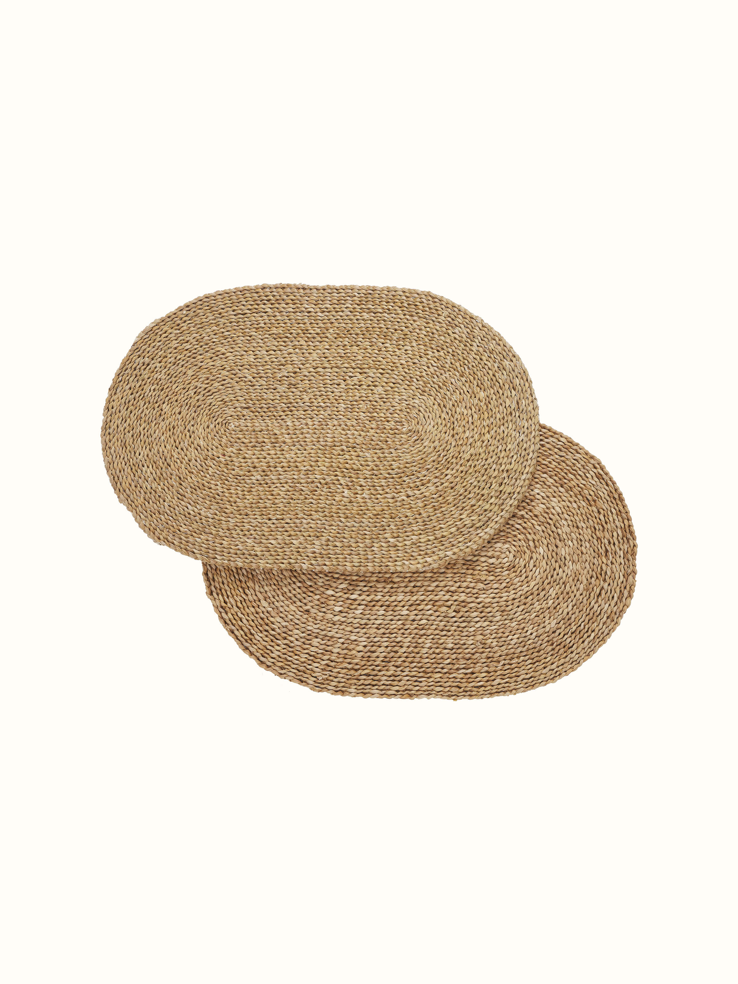 Full view of Vritti brown solid oval natural fibre trivets, showcasing their natural texture and shape.