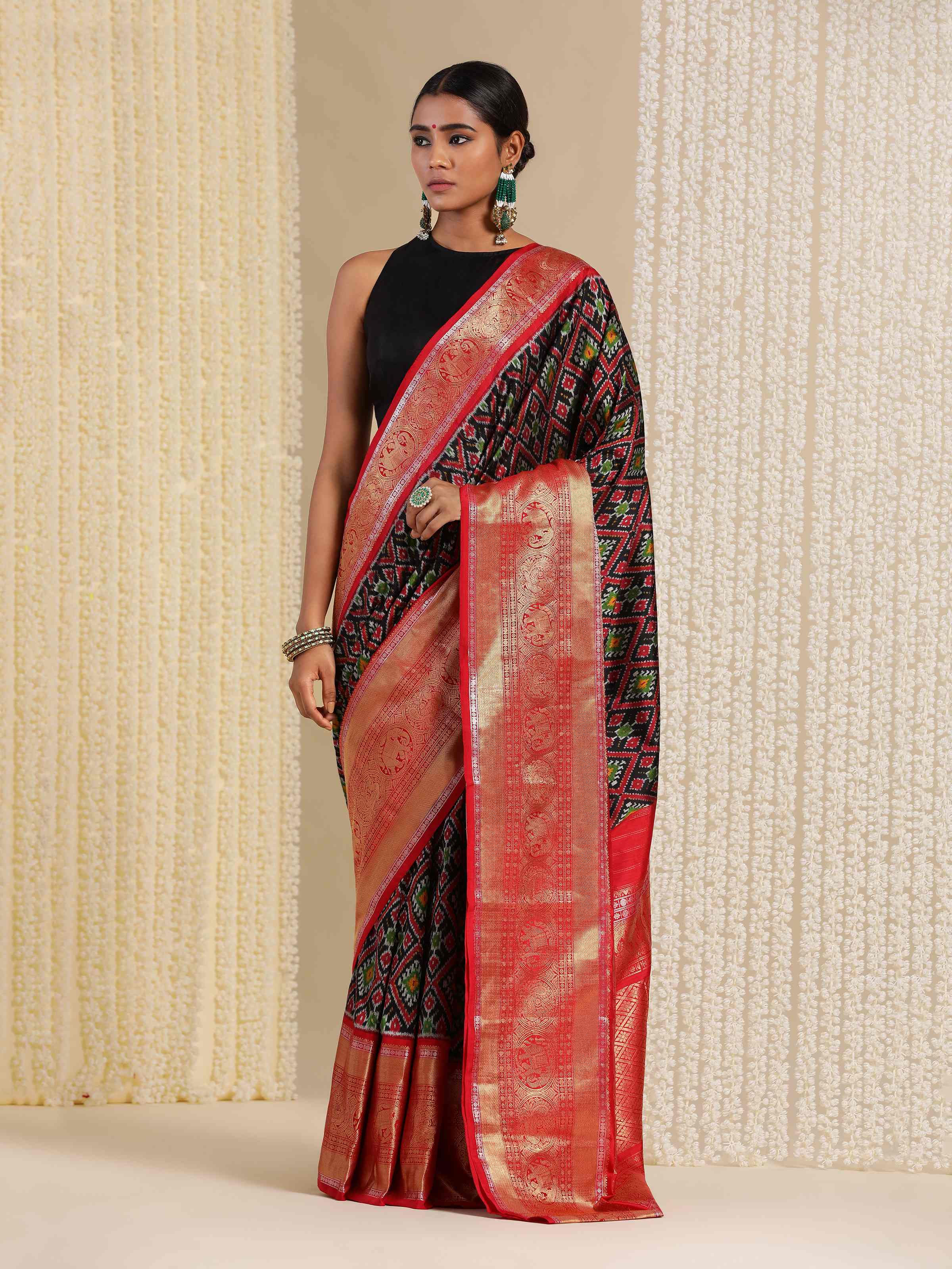 Model styled in blue Ikat silk saree in a modern setting, mid-length pose.