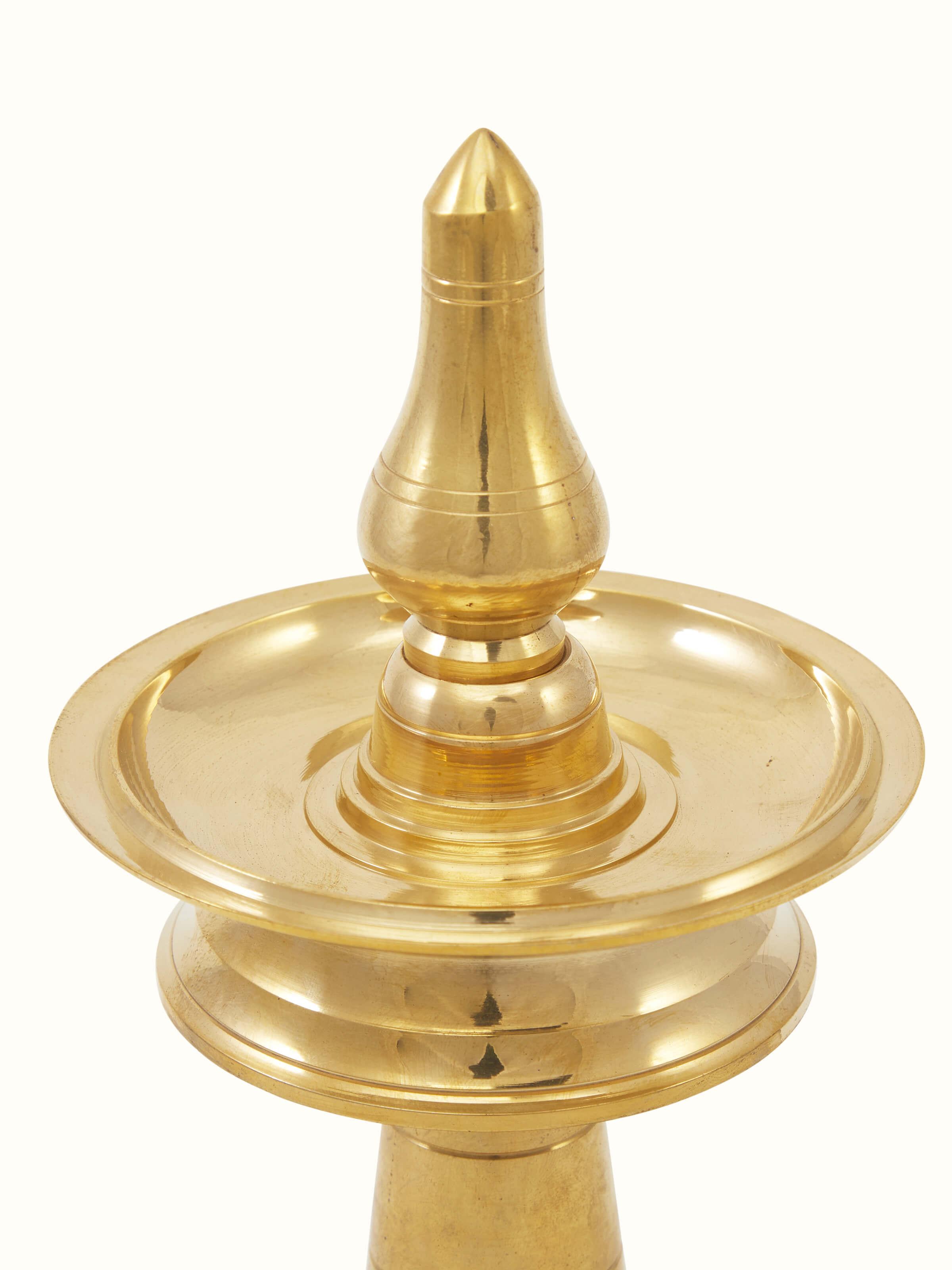 Side view of traditional brass samai vilakku stand diya displaying detailed engraving and classic design