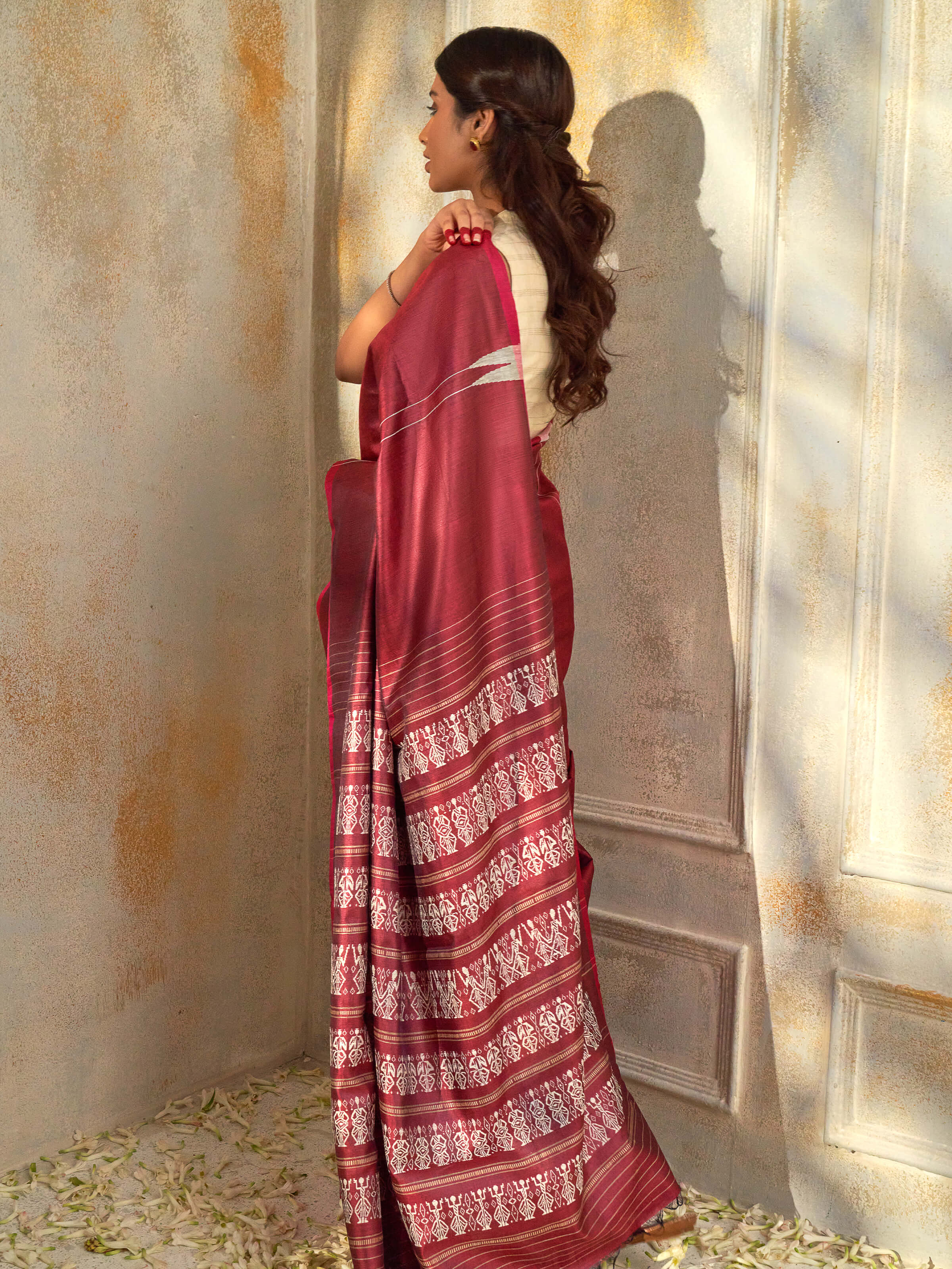 Angled view of maroon tussar silk Odisha ikat saree highlighting ikat weave