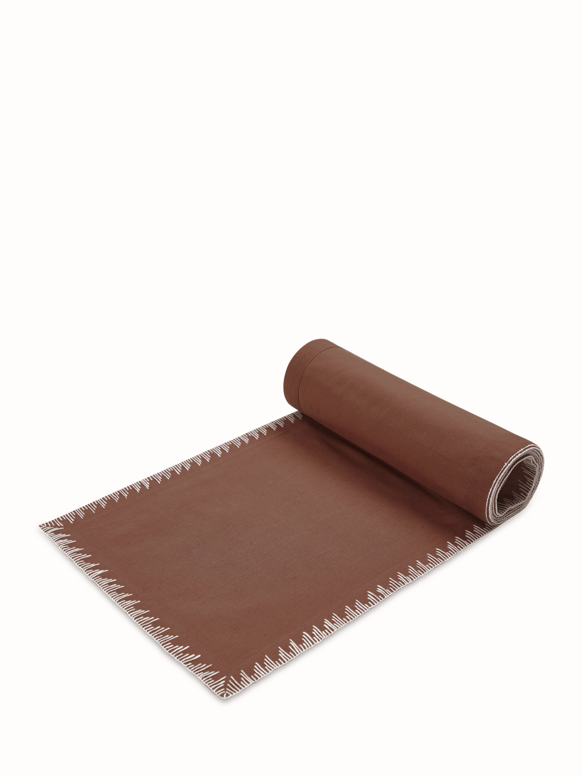 Angled view of Parvat brown linen cotton embroidered table mat
