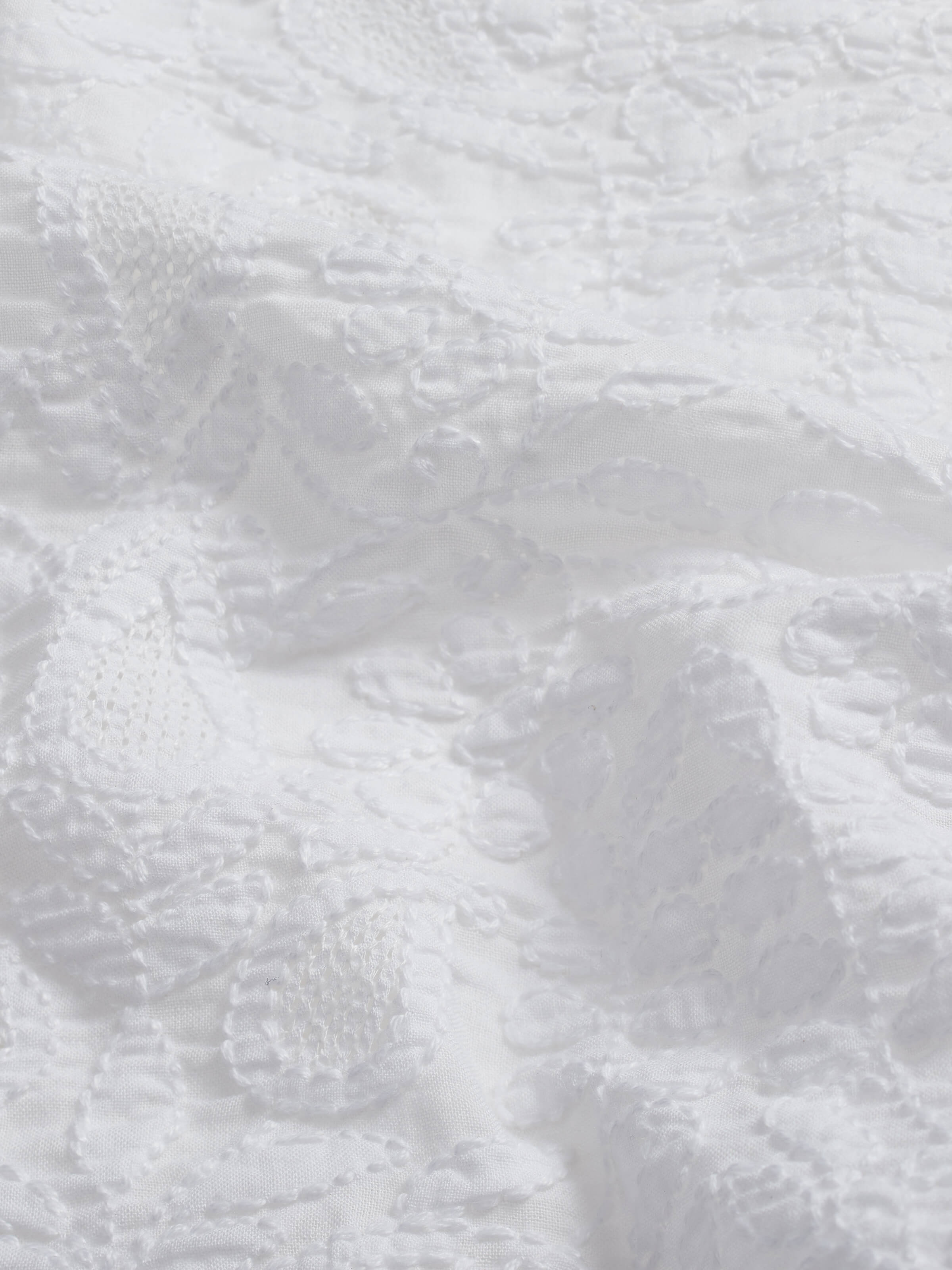 Side view showing the table cover’s fine weave and embroidery depth