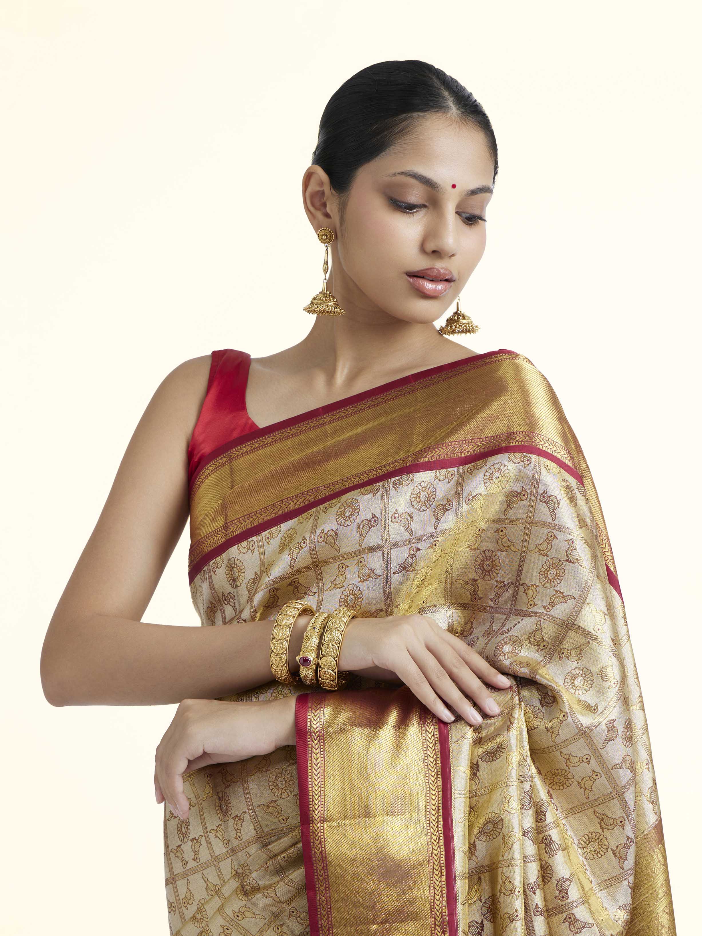 Angled view of gold silk Kancheepuram saree highlighting traditional weave and sheen