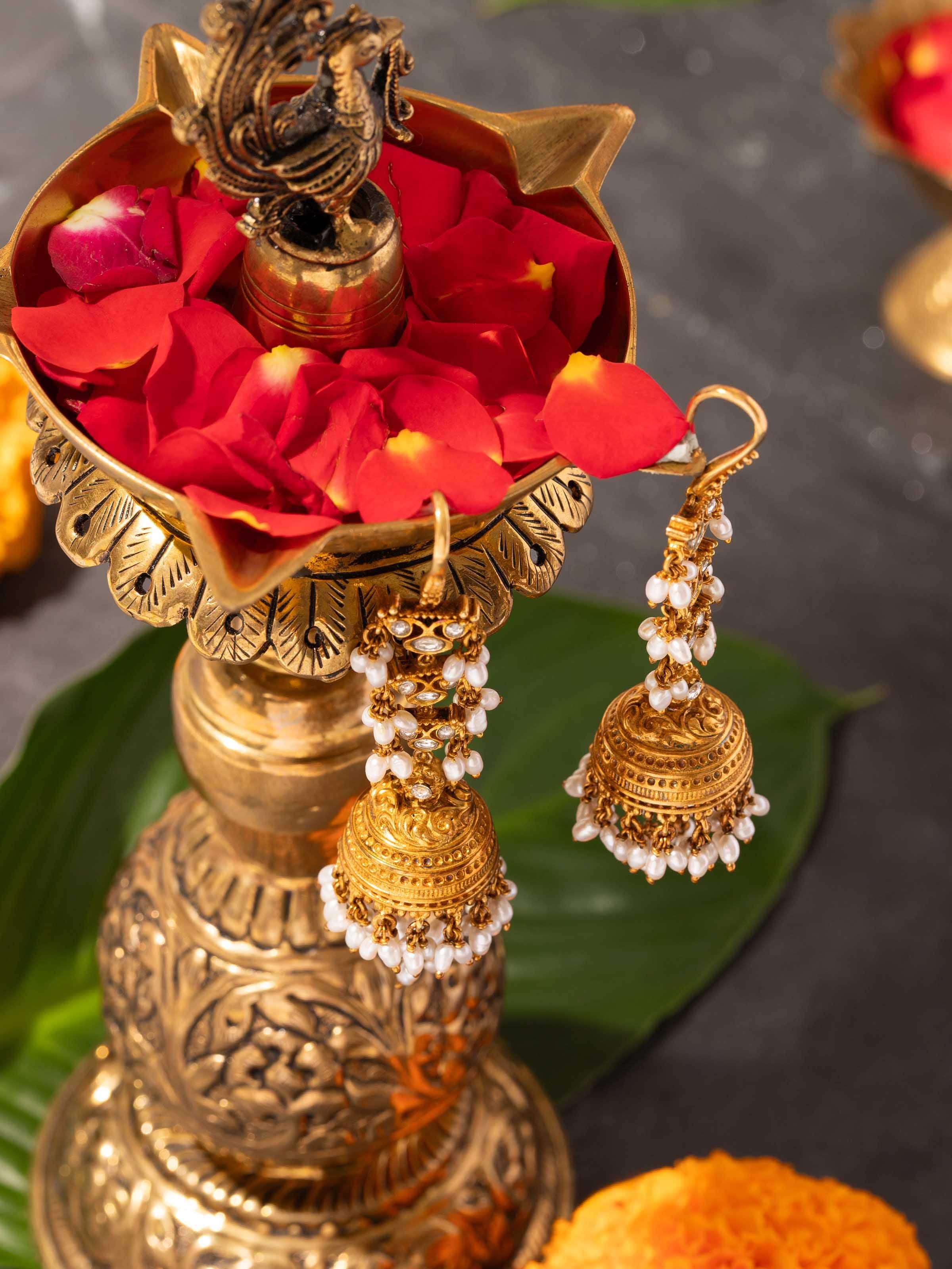 Woman wearing Guttapusalu jhumkas paired with traditional saree, enhancing heritage look.