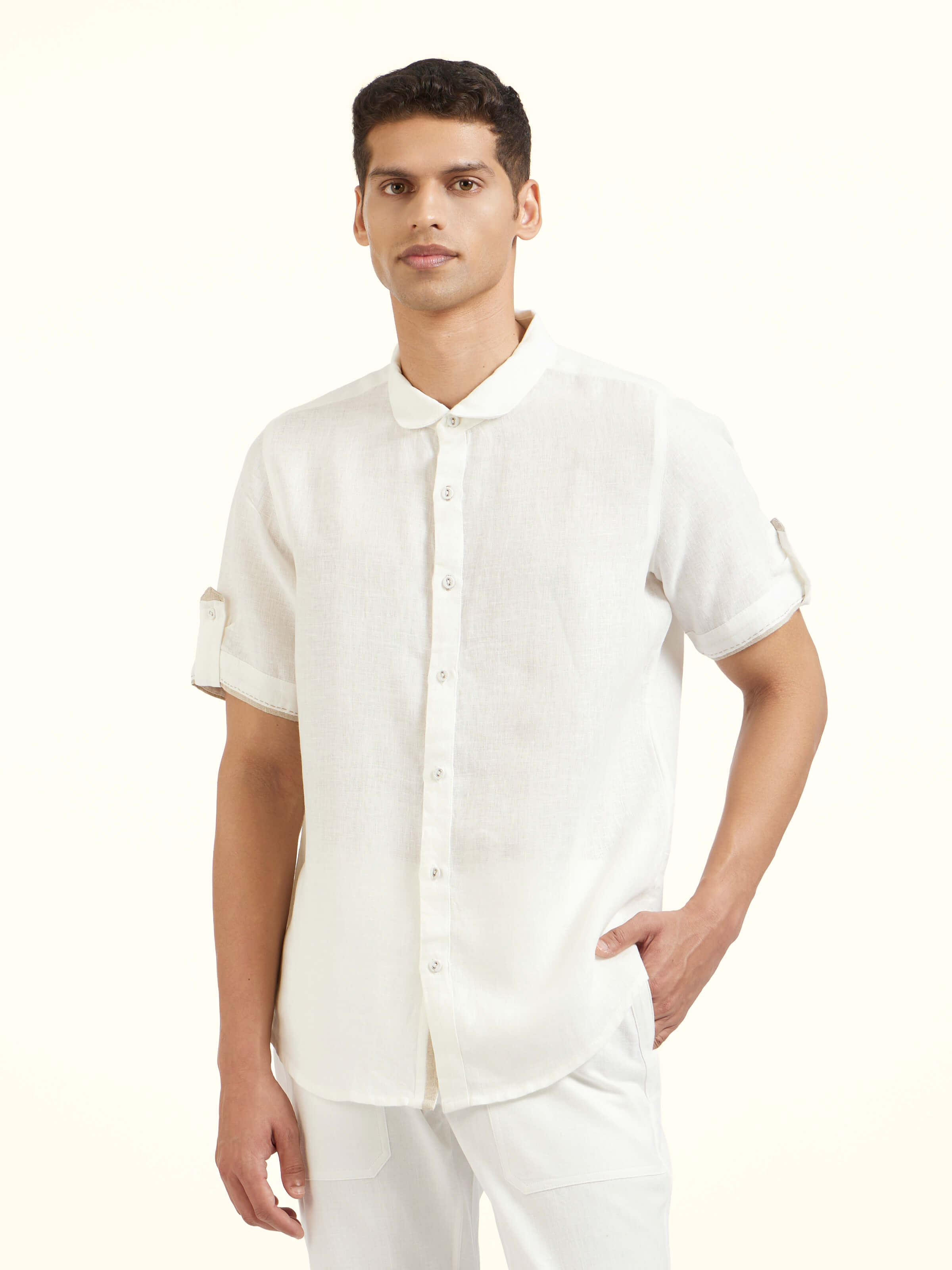 Angled view of white Peter Pan collar linen shirt highlighting collar and placket