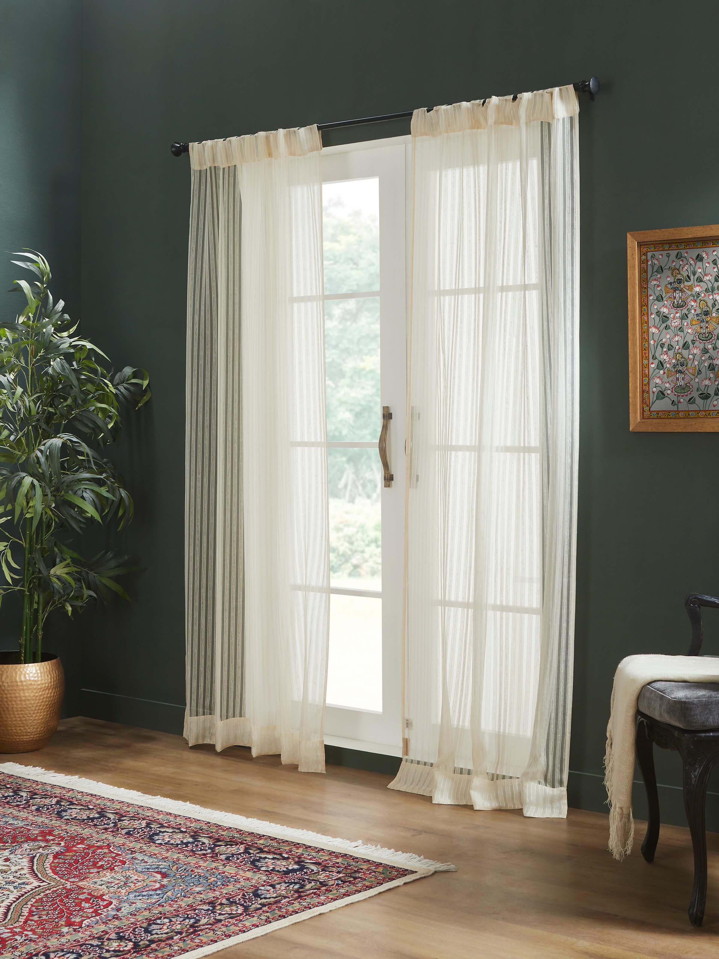 Styled room view of sheer beige curtain letting in natural light with elegant silk texture.