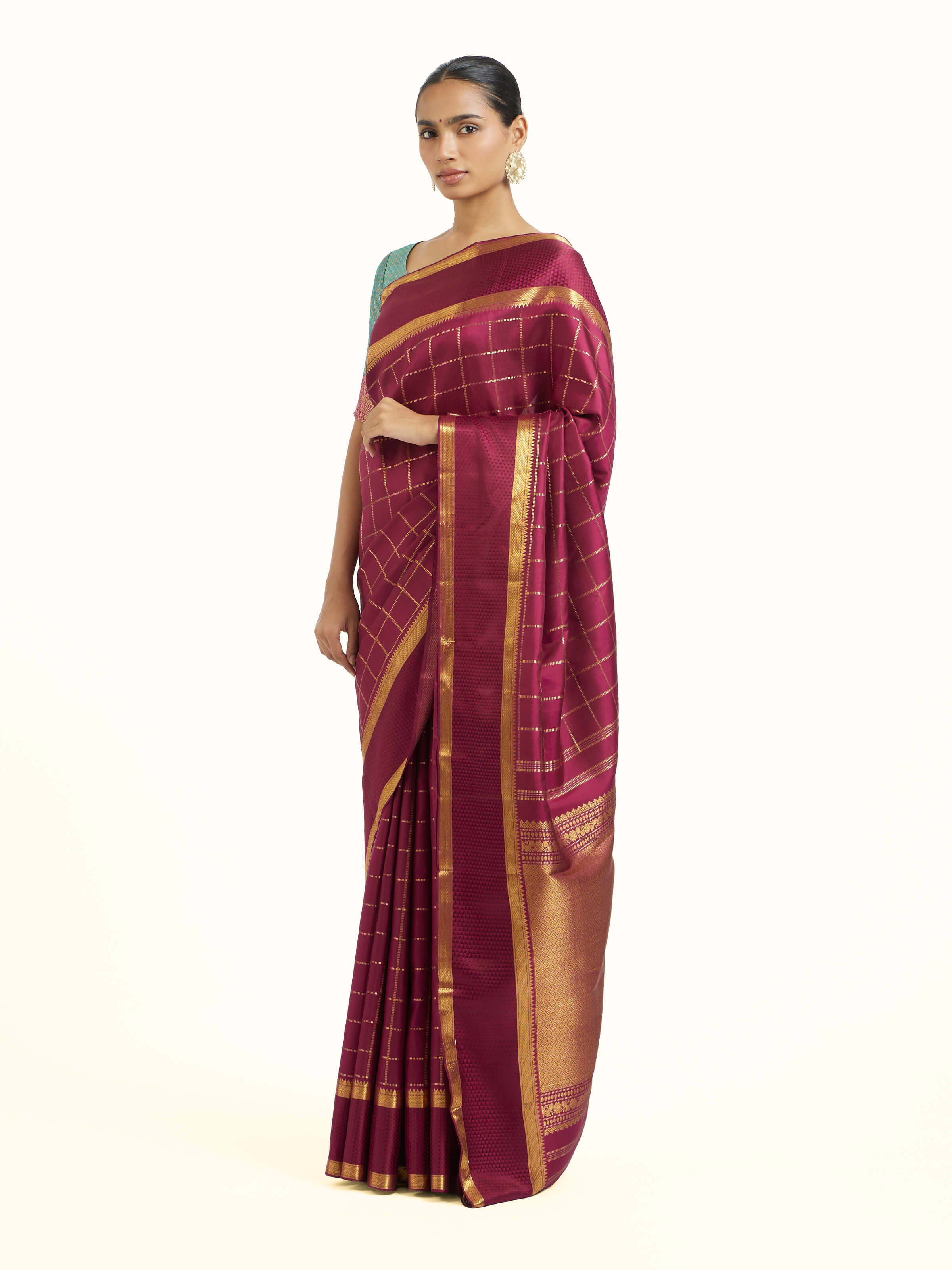Side view of burgundy silk Kancheepuram saree showcasing elegant drape
