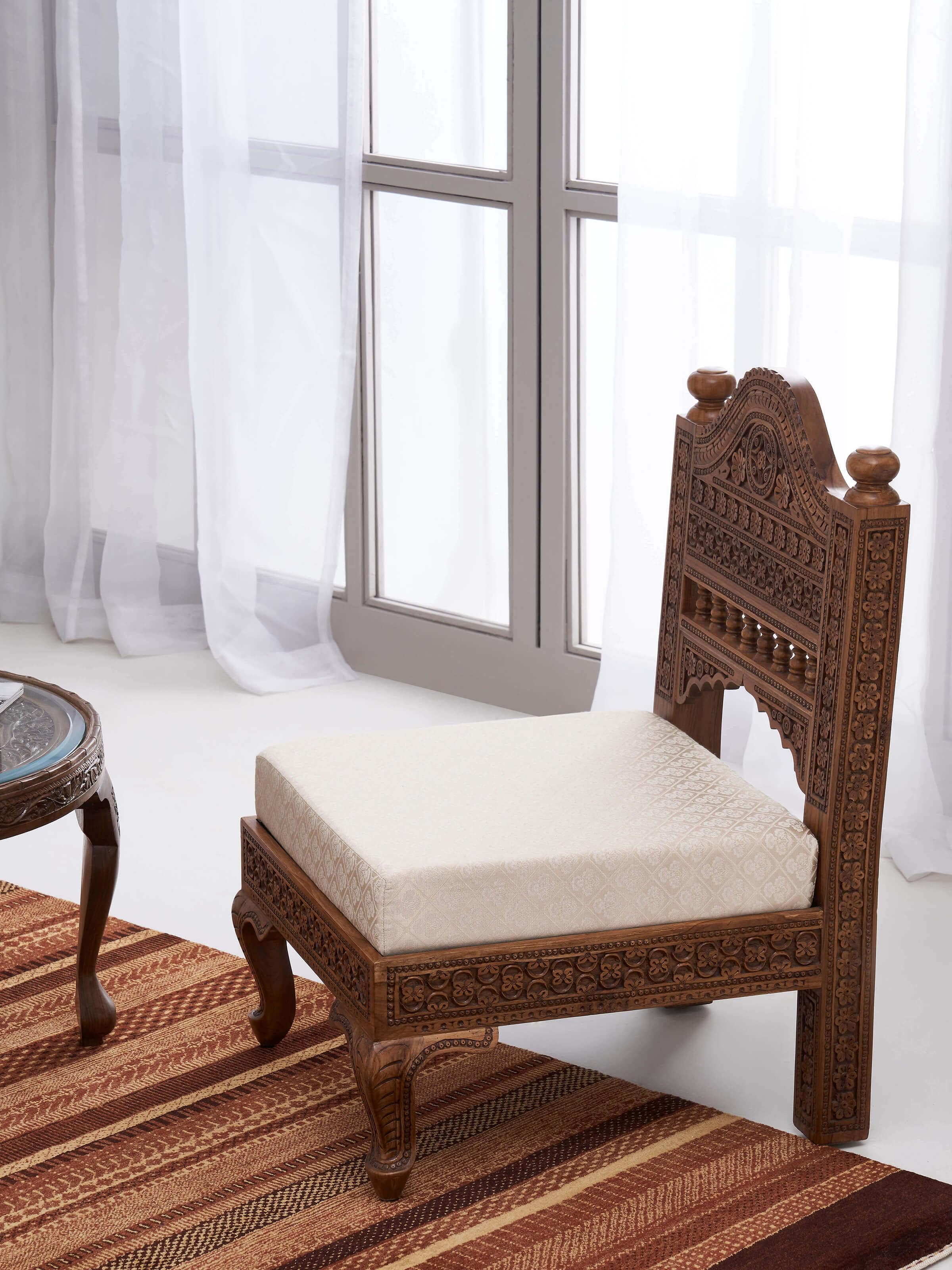 Side view of Carved Sheesham Wood Upholstered 1-seater Sofa displaying intricate carvings and plush cushioning.