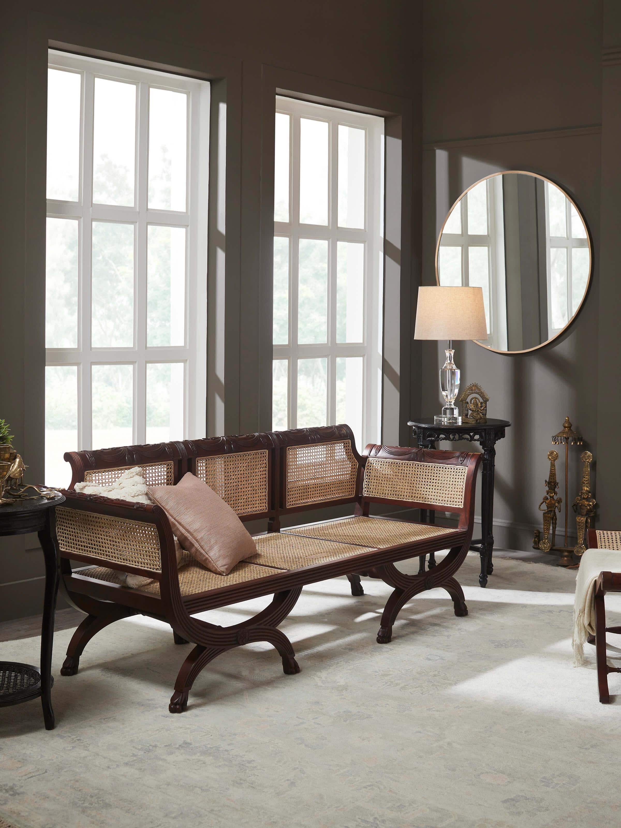 Lifestyle shot of traditional Sheesham wood and cane armchair in a cozy room setup – rustic artisan furniture