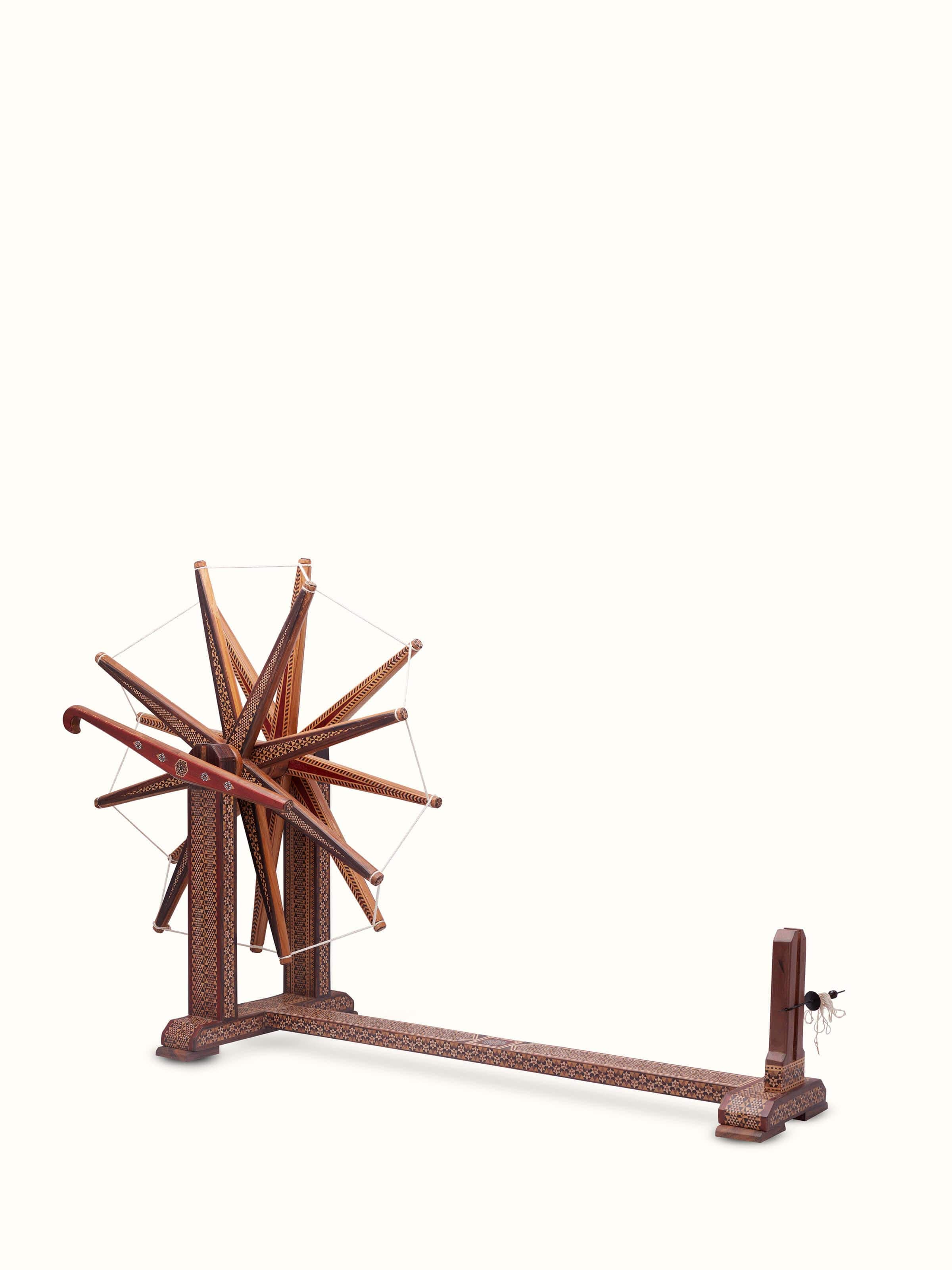 Angled view of Marquetry Rosewood Charkha in Multicolor