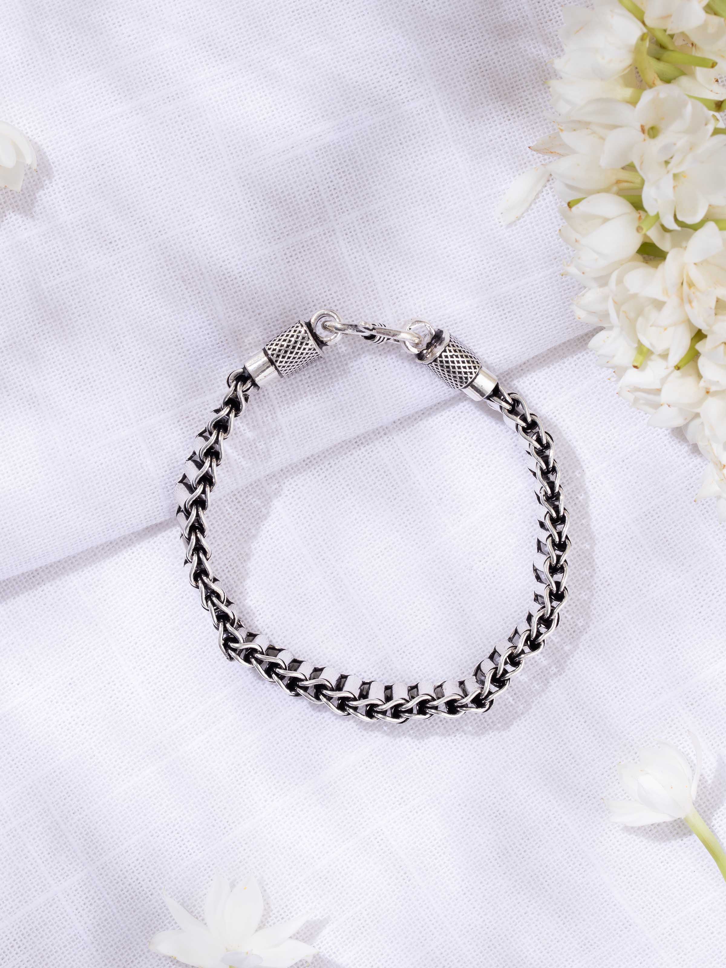 Lifestyle view of men’s silver bracelet worn on wrist to show rugged elegance