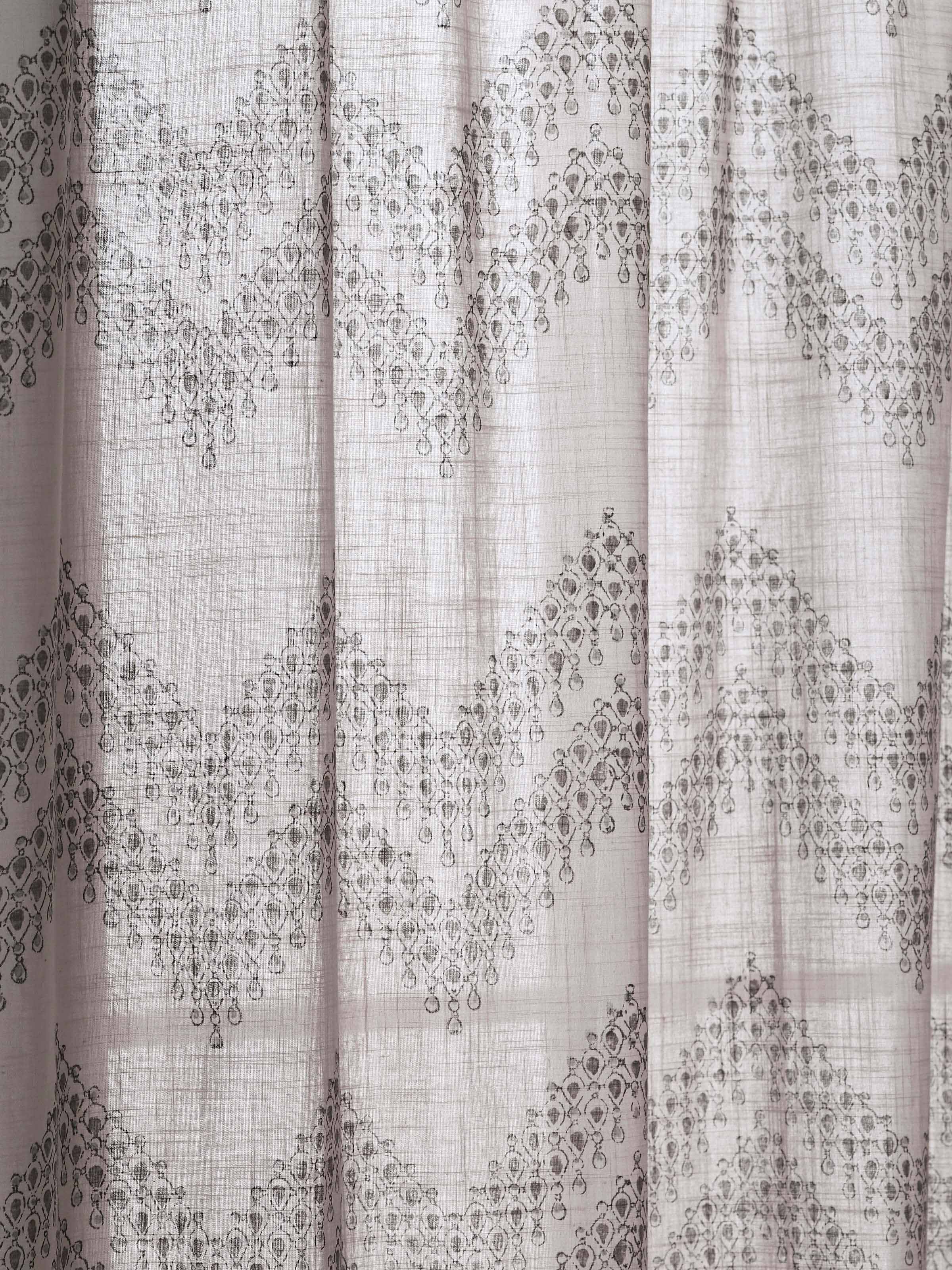 Macro shot highlighting Sanganeri print and weave texture on light grey cotton curtain