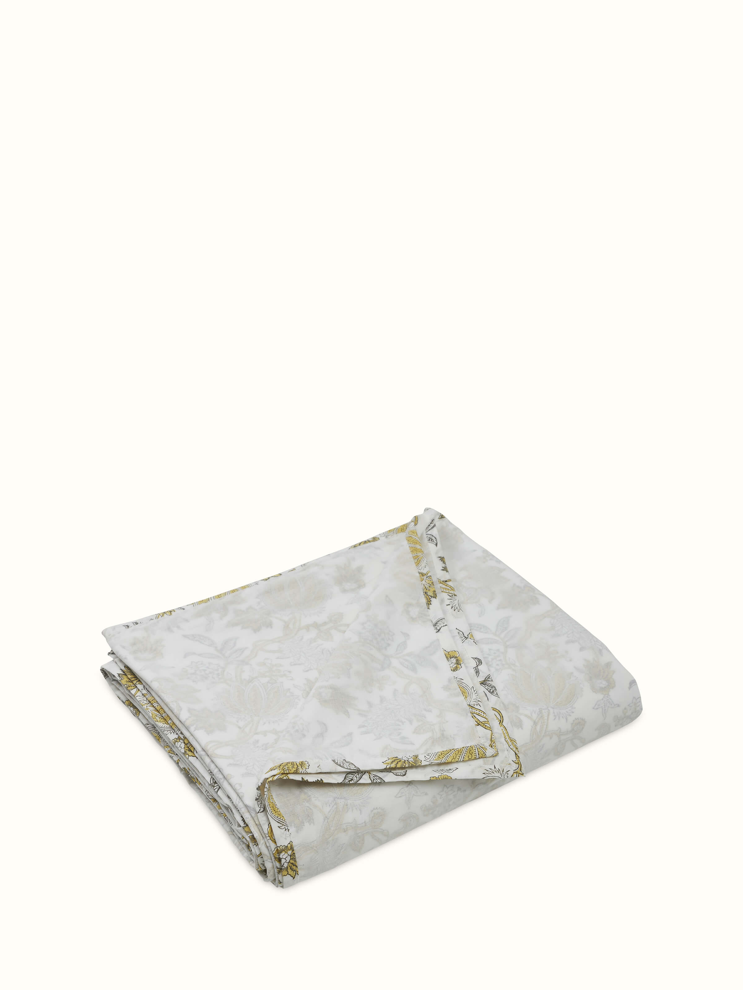 Angled close-up of floral block print on yellow cotton dohar.