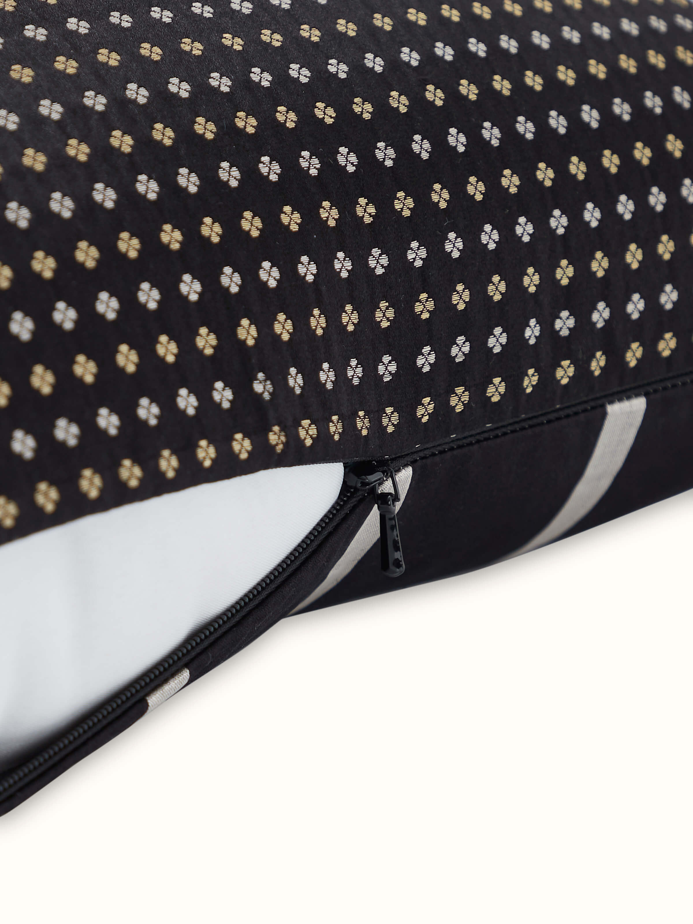 Angled side view of Awadh Banarasi Cushion, featuring black silk with subtle golden stripes.