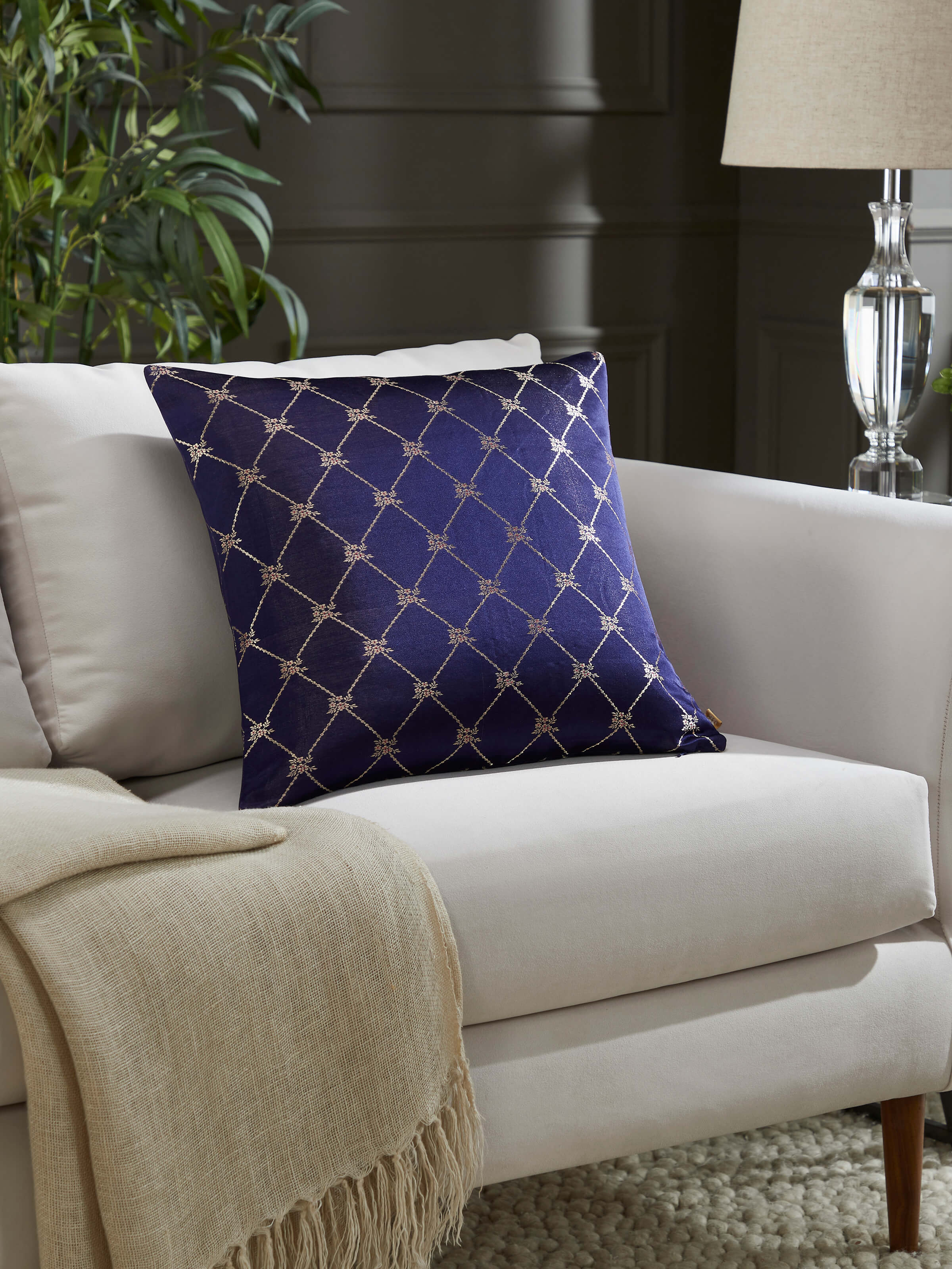 Lifestyle image showing the cushion styled in a traditional living room setup, highlighting its festive elegance.