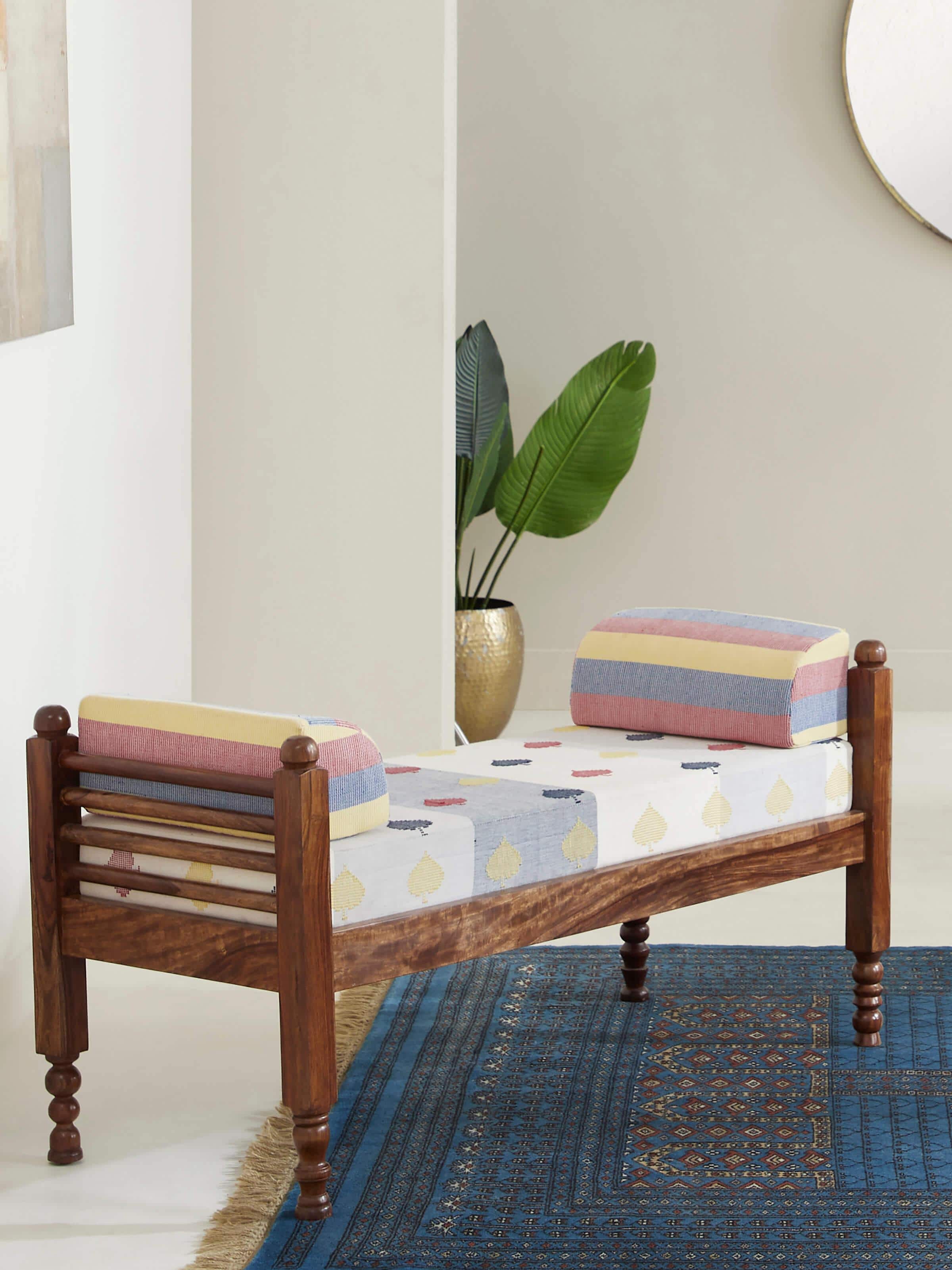 Side view of Bawan Buti upholstered Sheesham wood 2-seater bench showcasing intricate carvings and rich wooden finish.