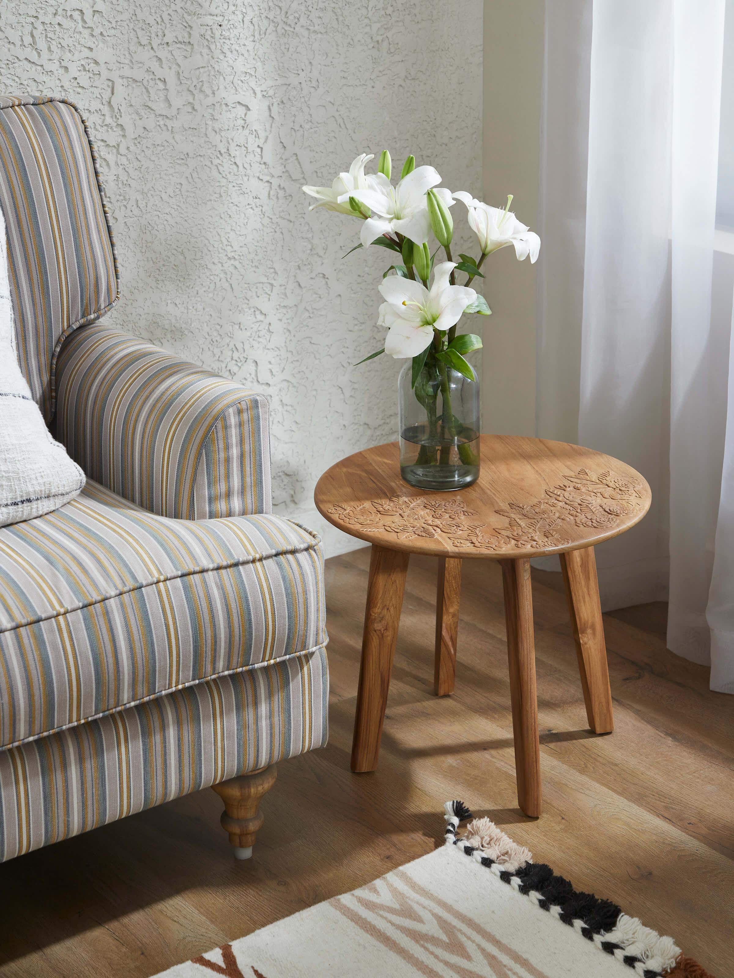 Side view of the carved teak wood round side table, highlighting its elegant design and smooth finish