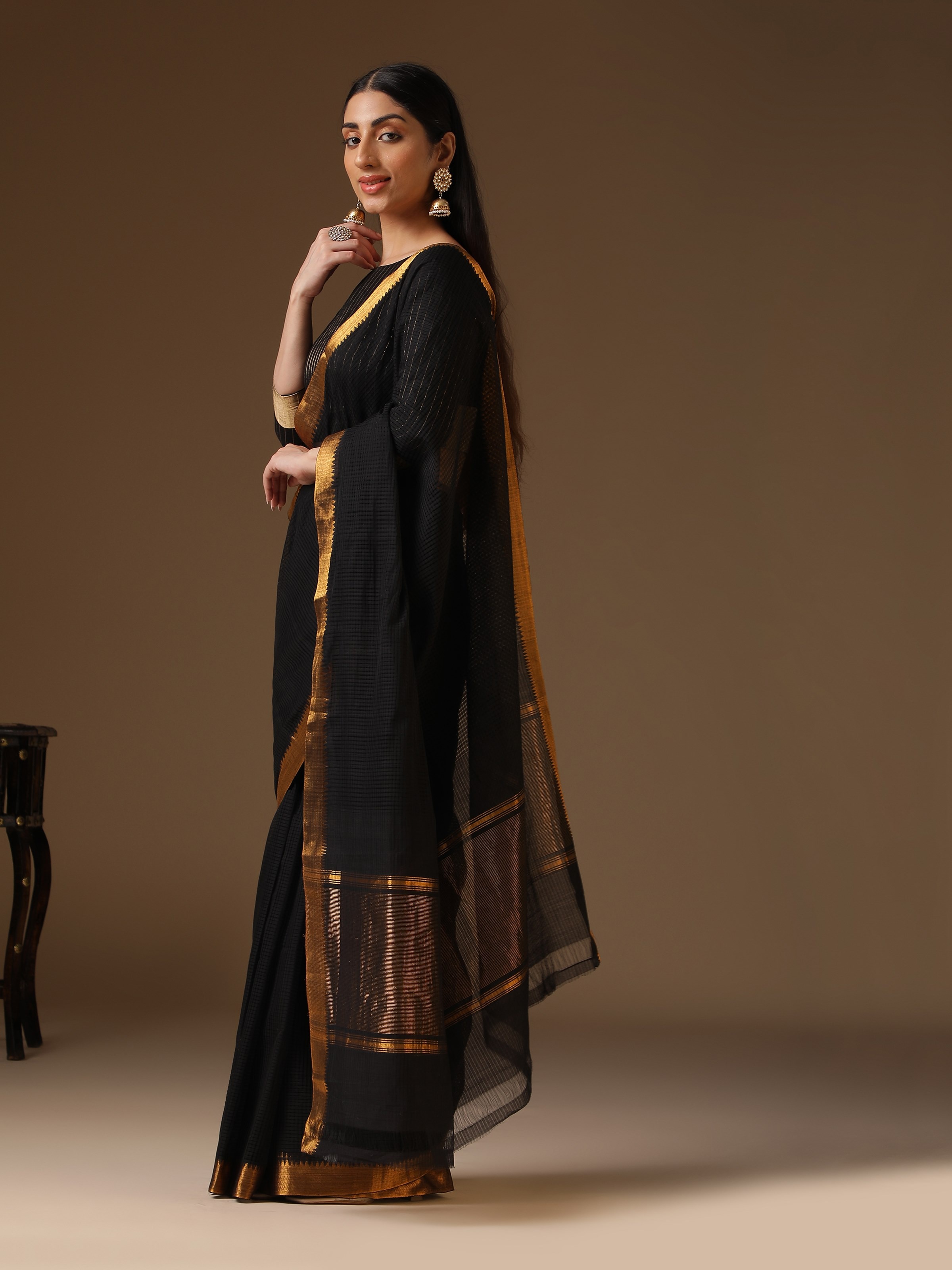 Angled view of black cotton blend Mangalgiri saree showing fabric sheen and traditional weave pattern.